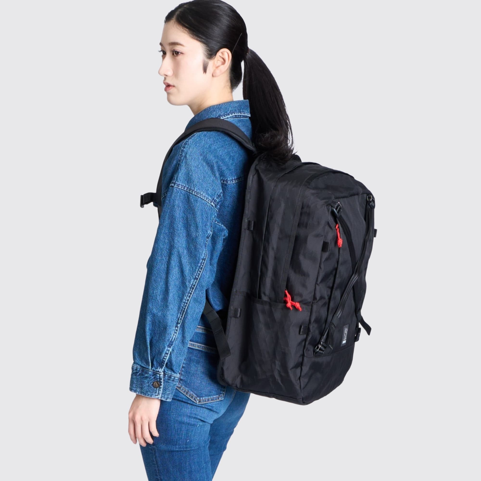 A woman wearing the Cohesive 38L Pack on her back