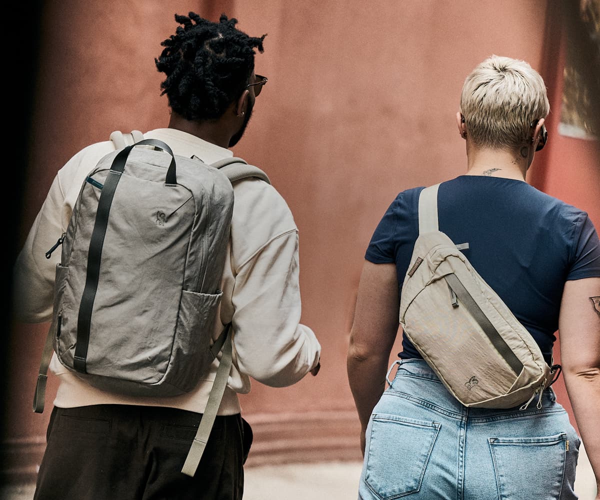 A man wearing a district backpack and woman wearing a sling