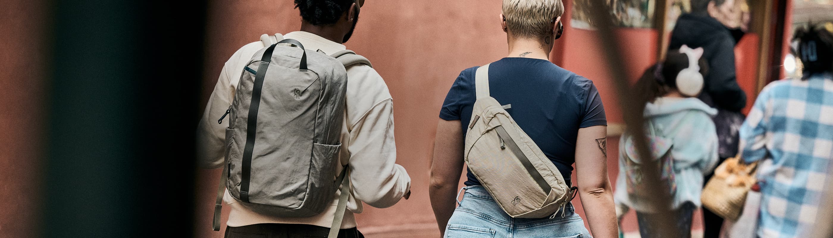 A woman wearing a district sling and a man wearing a backpack
