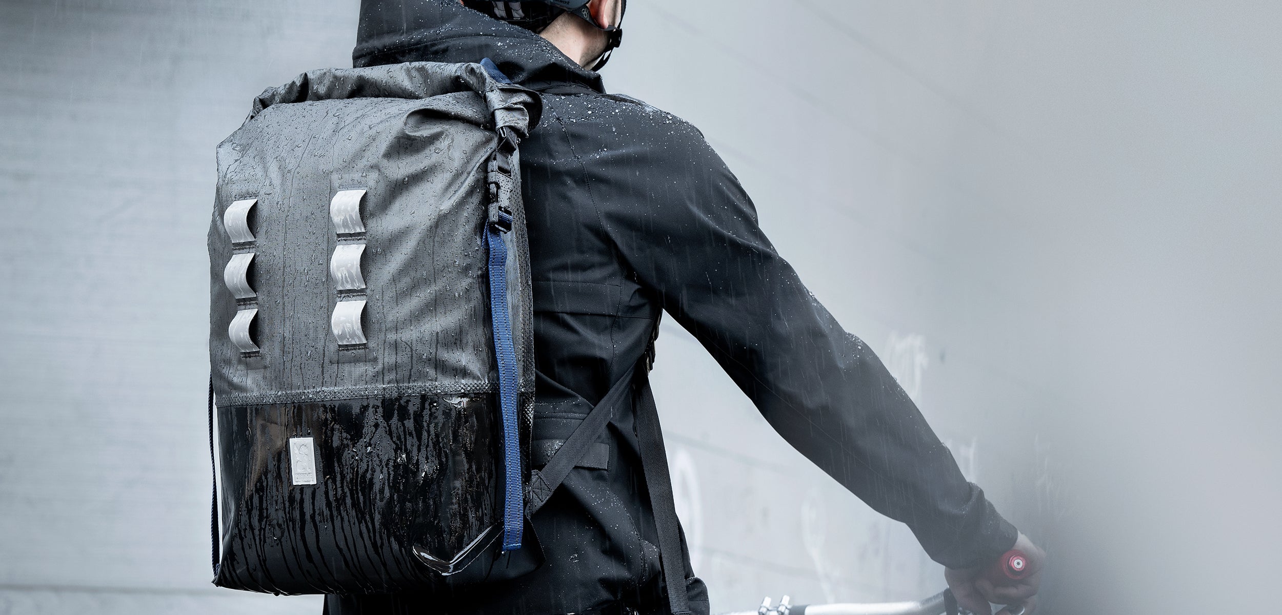 Waterproof Urban Ex bag on a guy riding a bike in the rain desktop size image