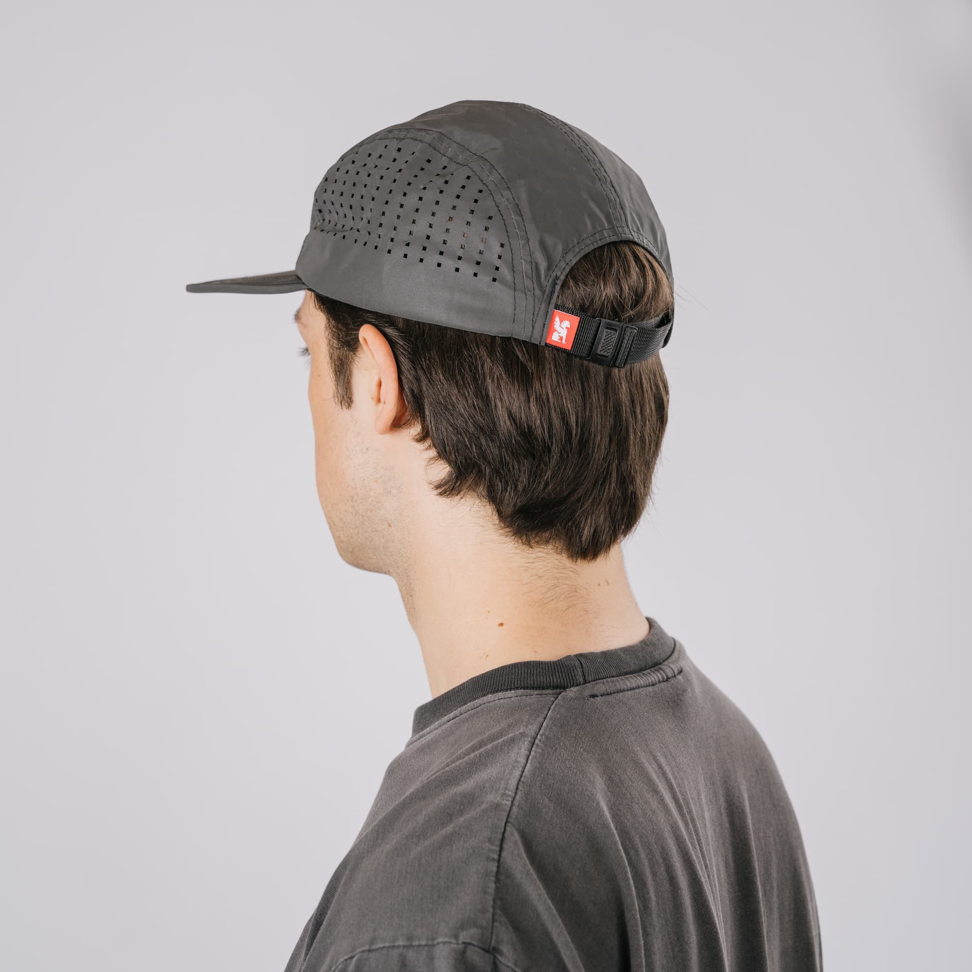 The back of the new Chrome Industries Five Panel Hat in black reflective on a guys head