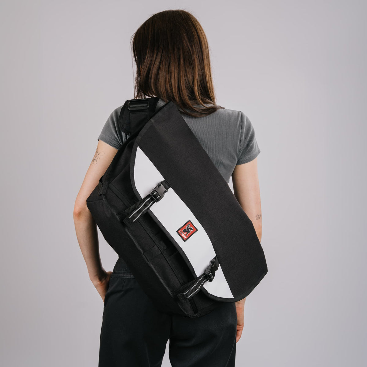 The Citizen 24L Messenger in new Classic Black White on the back of a woman #color_classic / black / white