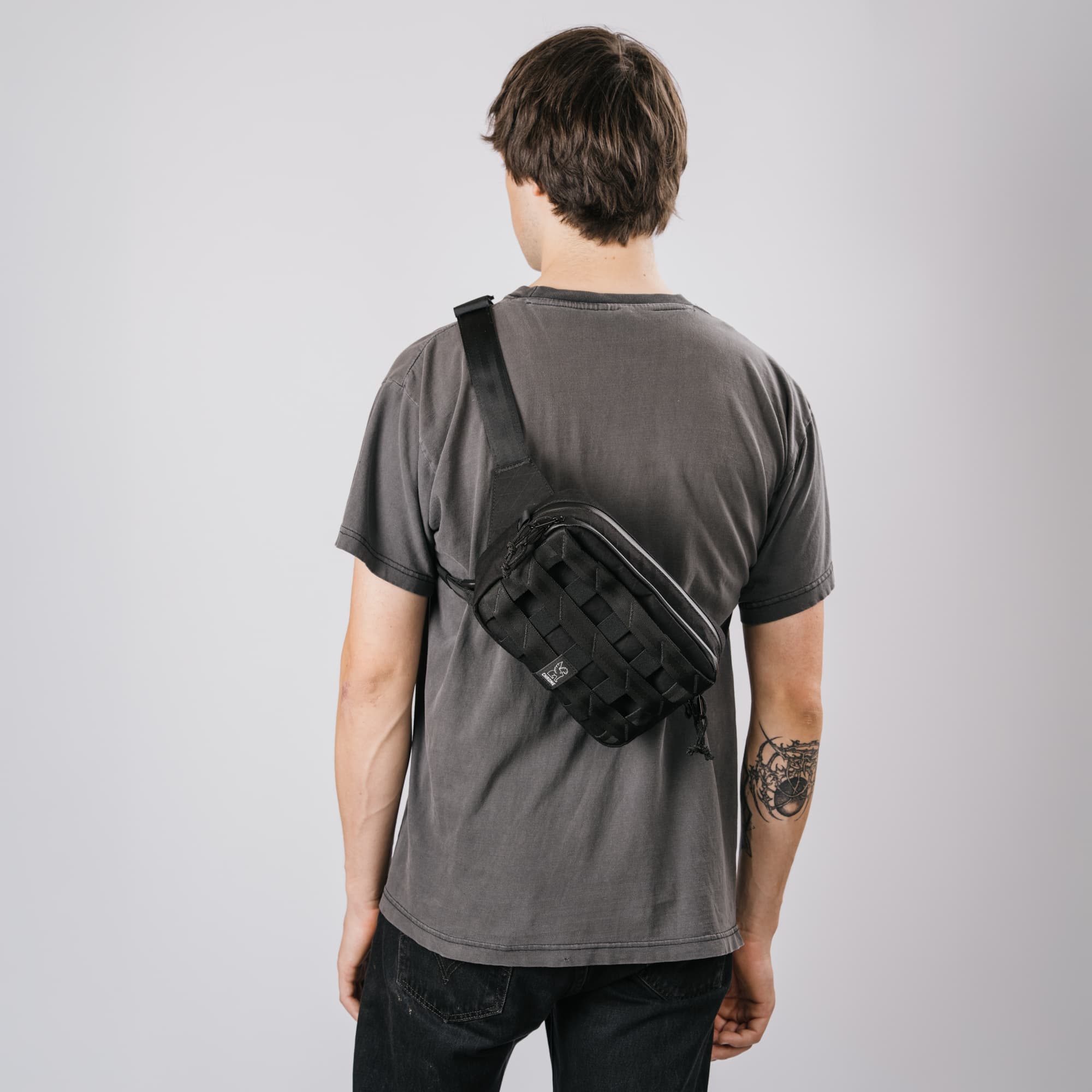 The Barrage 5L Sling on a guys back in the black x2 color