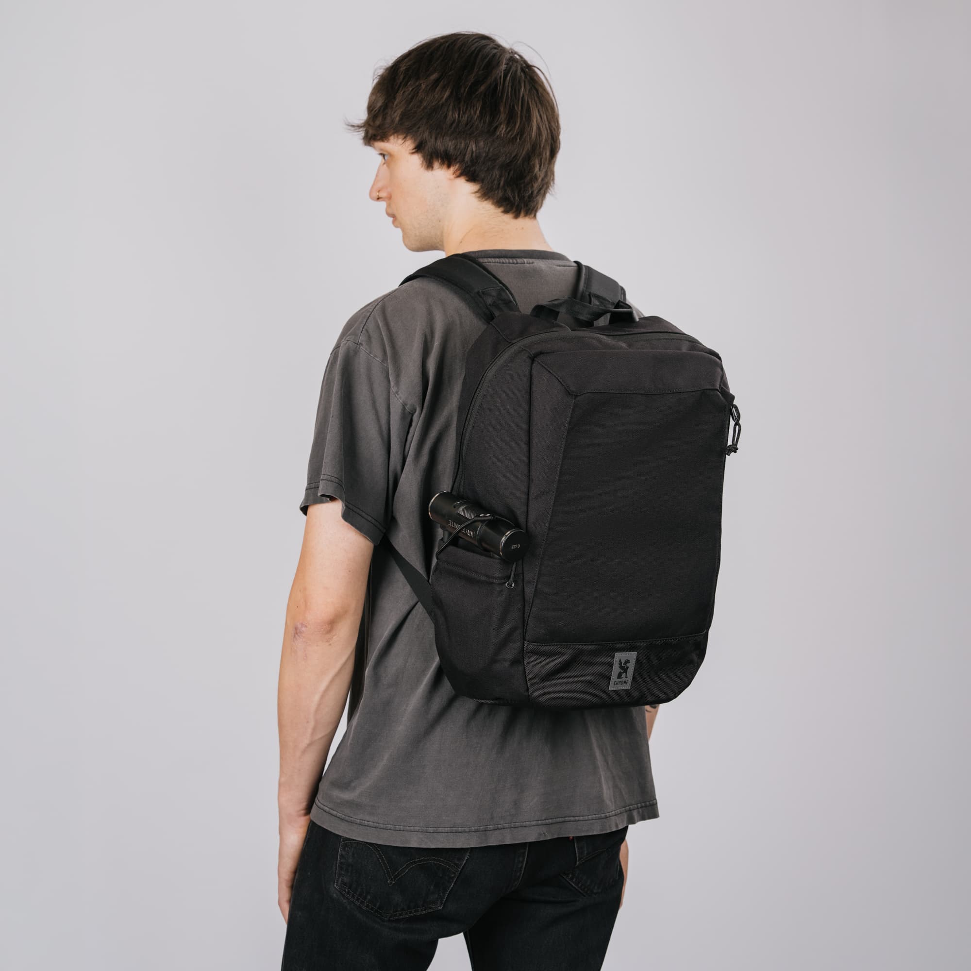 A man wearing the Recruit 22L Pack in black on his back.