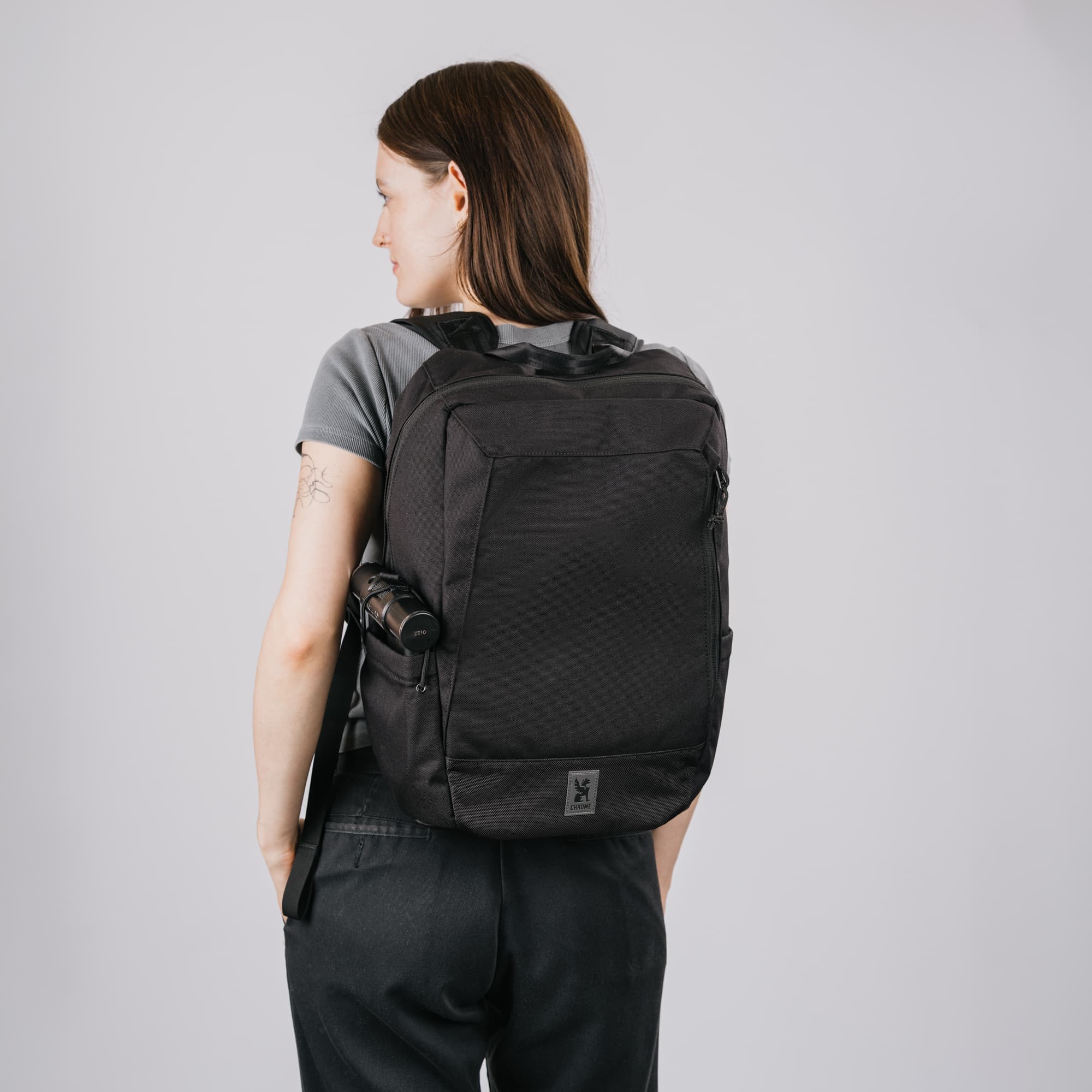 A woman wearing the new Recruit 22L Pack in black