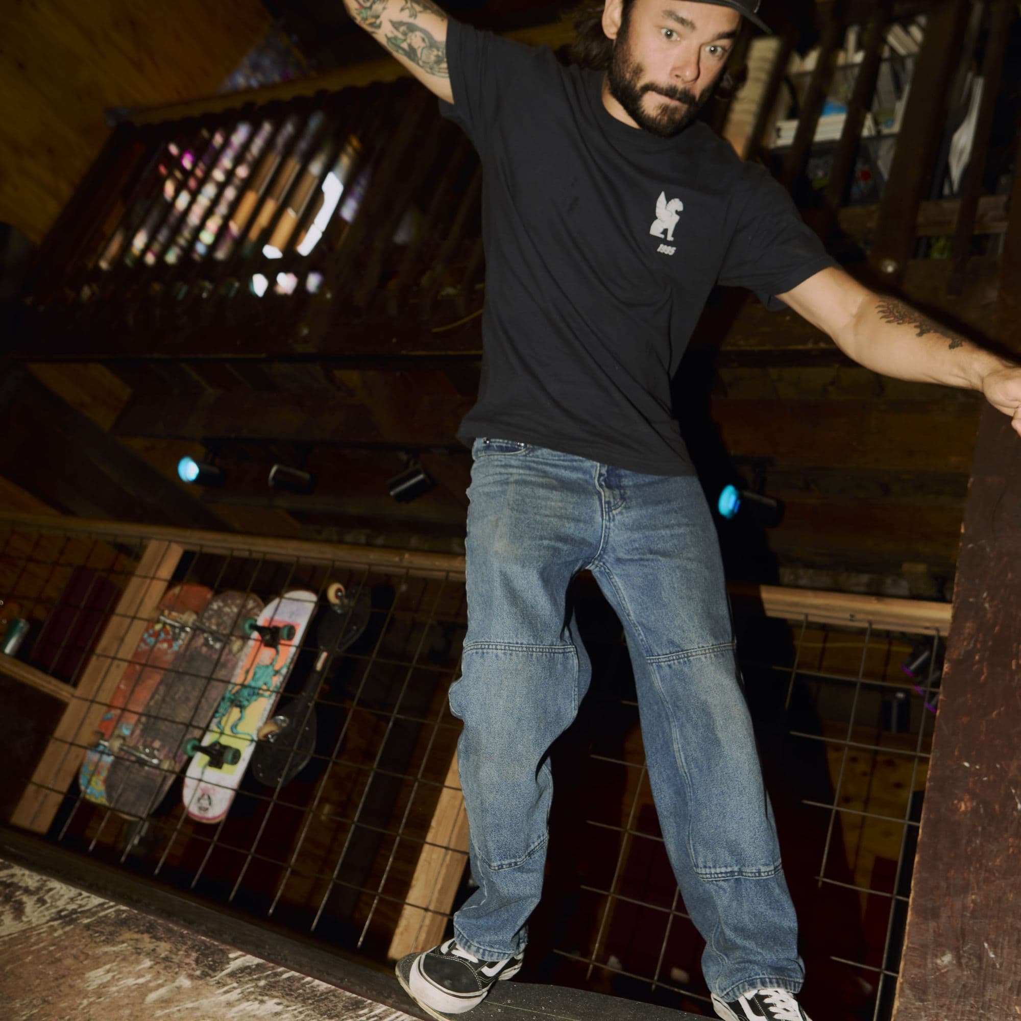 Man skating with the Chrome 30th Anniversary Tee on in black