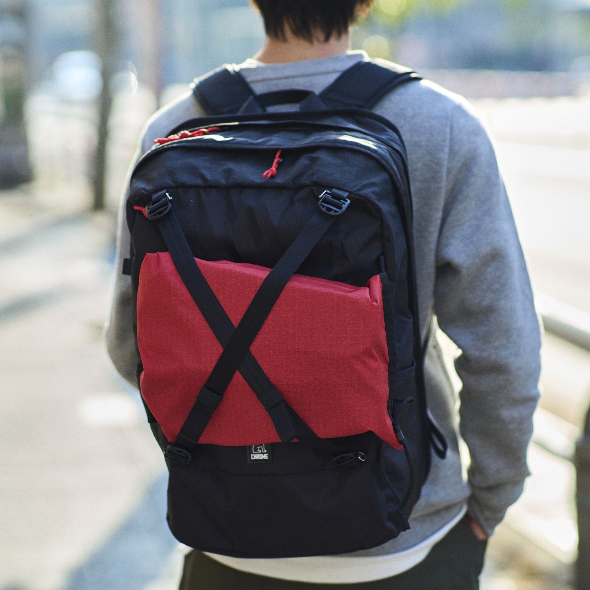 The adjustable cross straps on the back of the Cohesive carrying a package