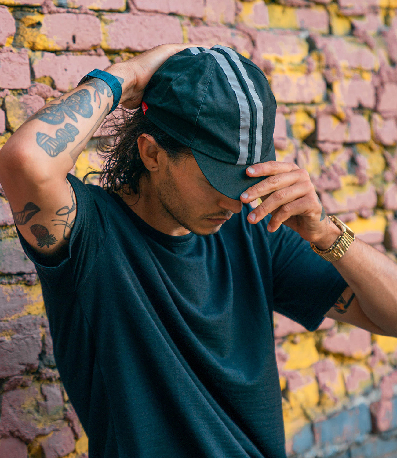 Cycling cap on a guy holding the brim mobile size