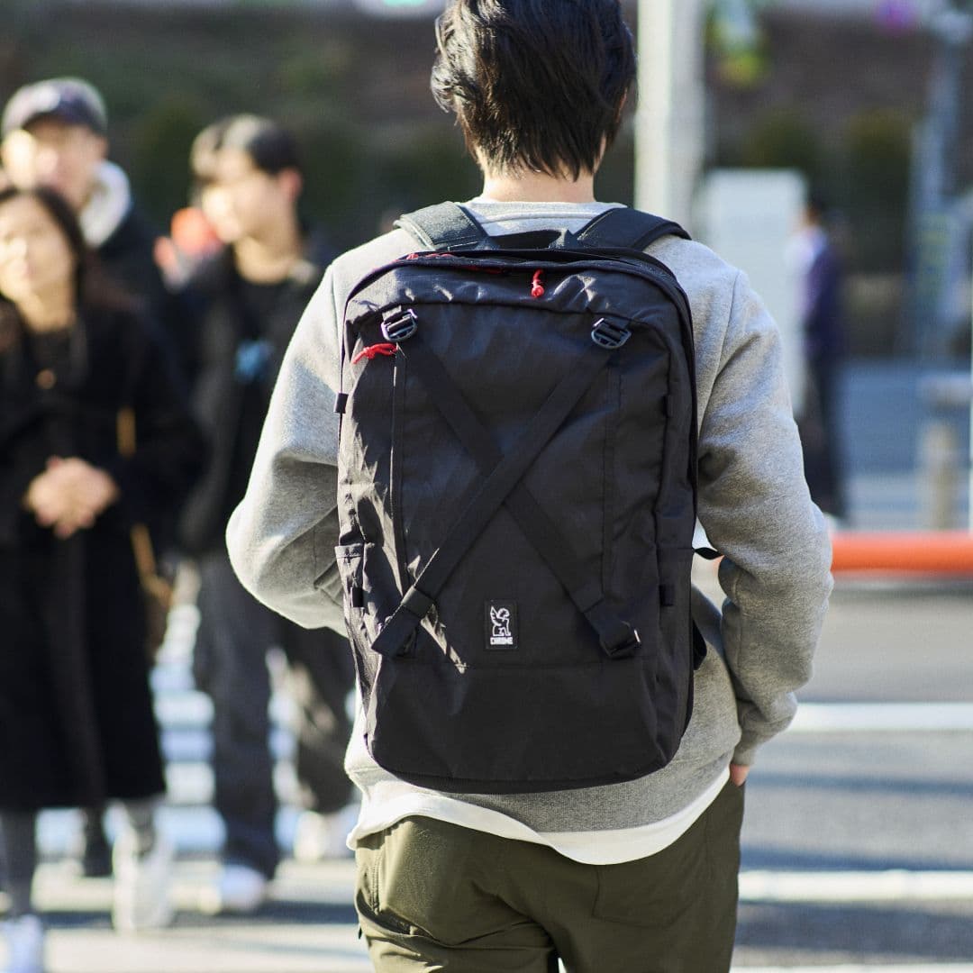 Person wearing a black Cohesive 38l backpack on a Tokyo city street