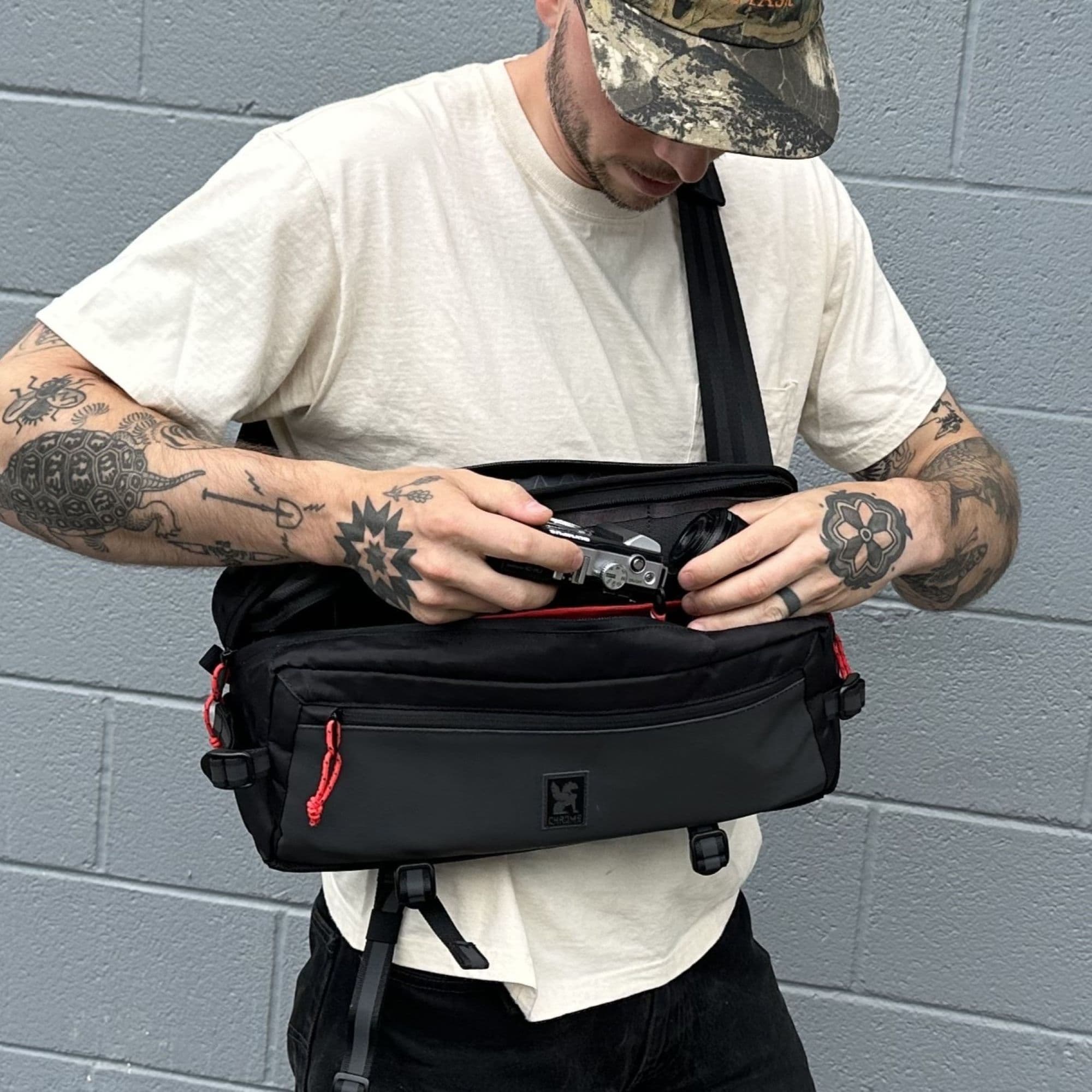 A guy using the Kadet Photo Insert inside of a Kadet Sling