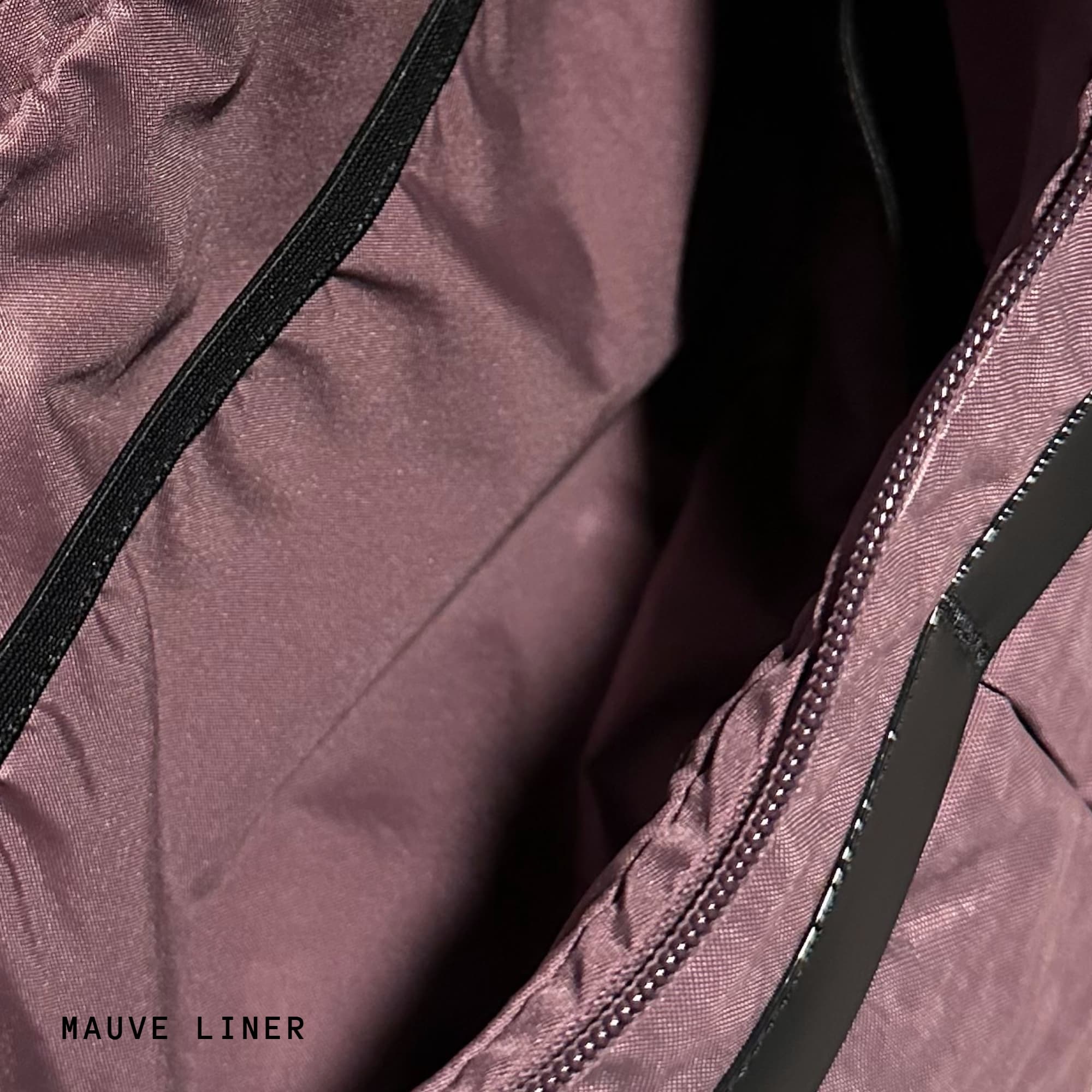 Close-up of a mauve fabric with black zipper and trim #color_mauve