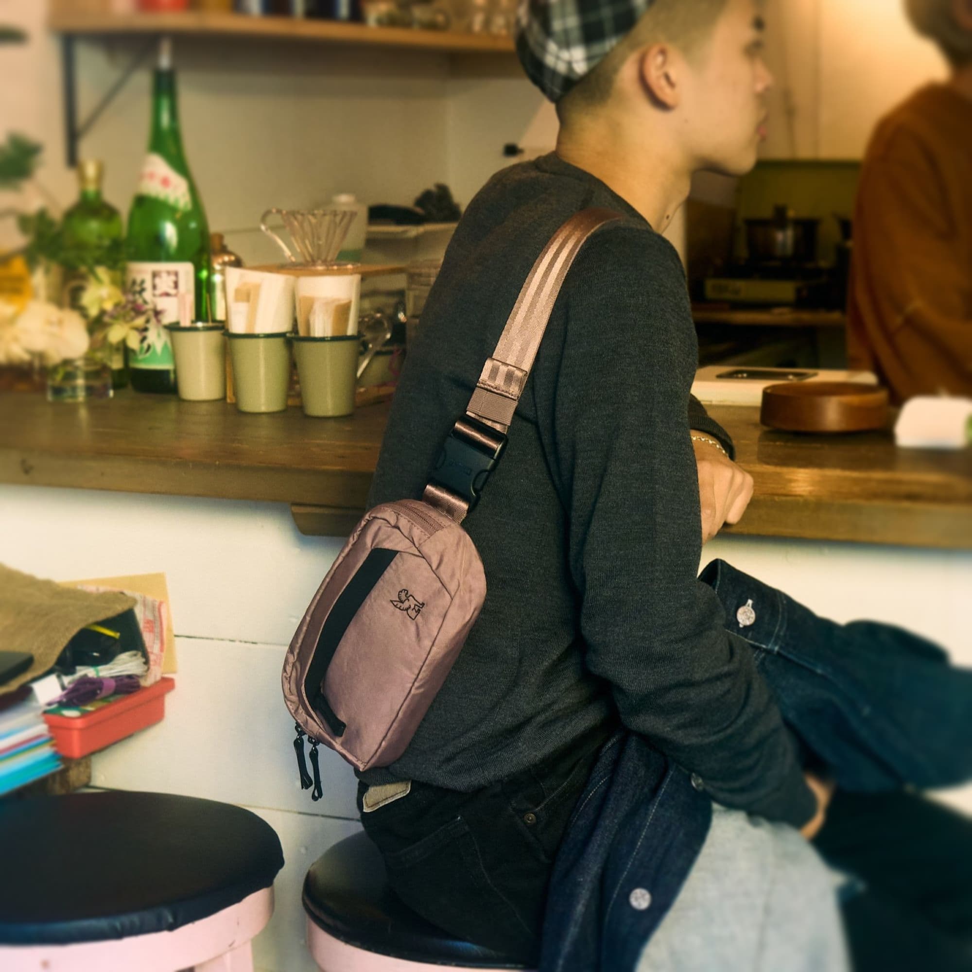 A person sitting at a lunch counter wearing the Sabin 1.5L Sling