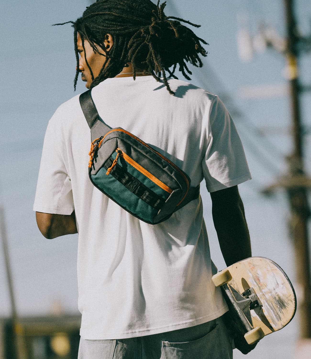 Water-resistant Ziptop Waistpack worn as a sling on a skateboarder