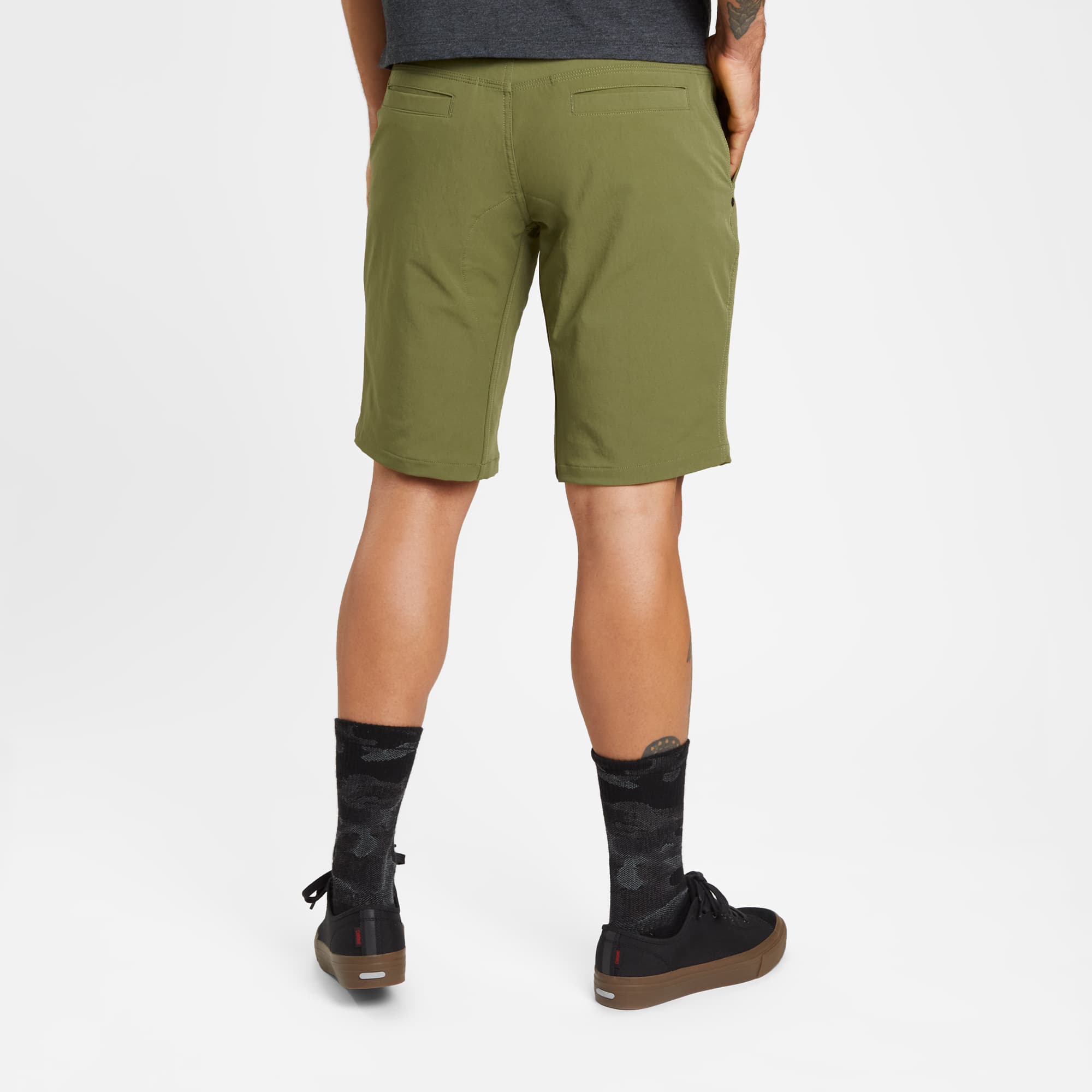 Men's Folsom tech biking Short in green worn by a man back view #color_olive branch
