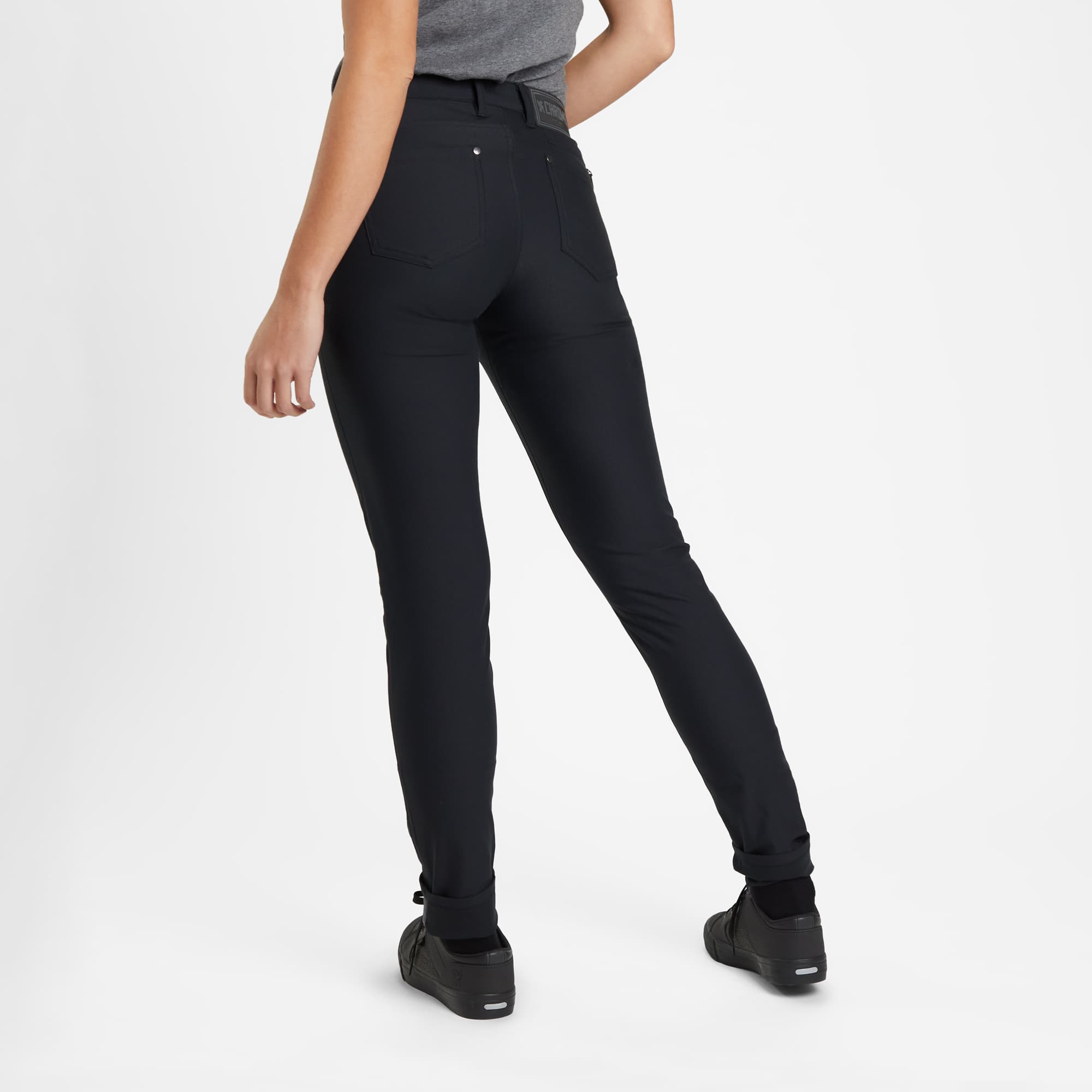 Women's 5 pocket pant in black worn by a woman back view full length