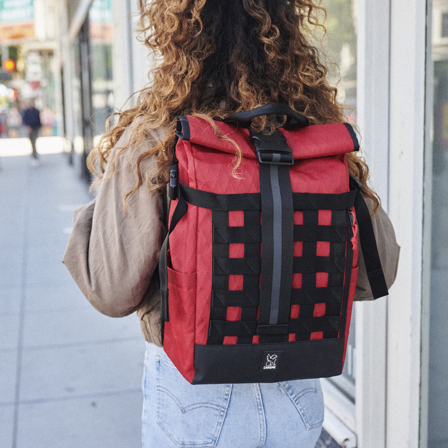 Woman wearing the red Barrage 18L pack