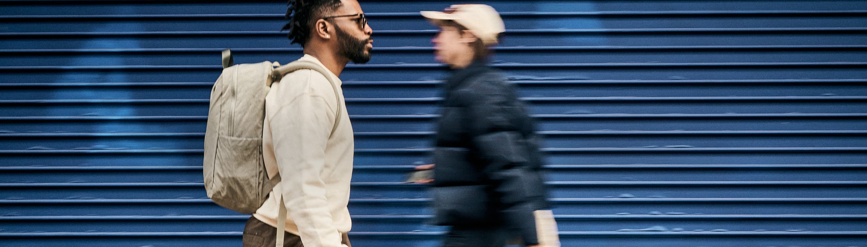 A guy wearing the Highline backpack in Sage