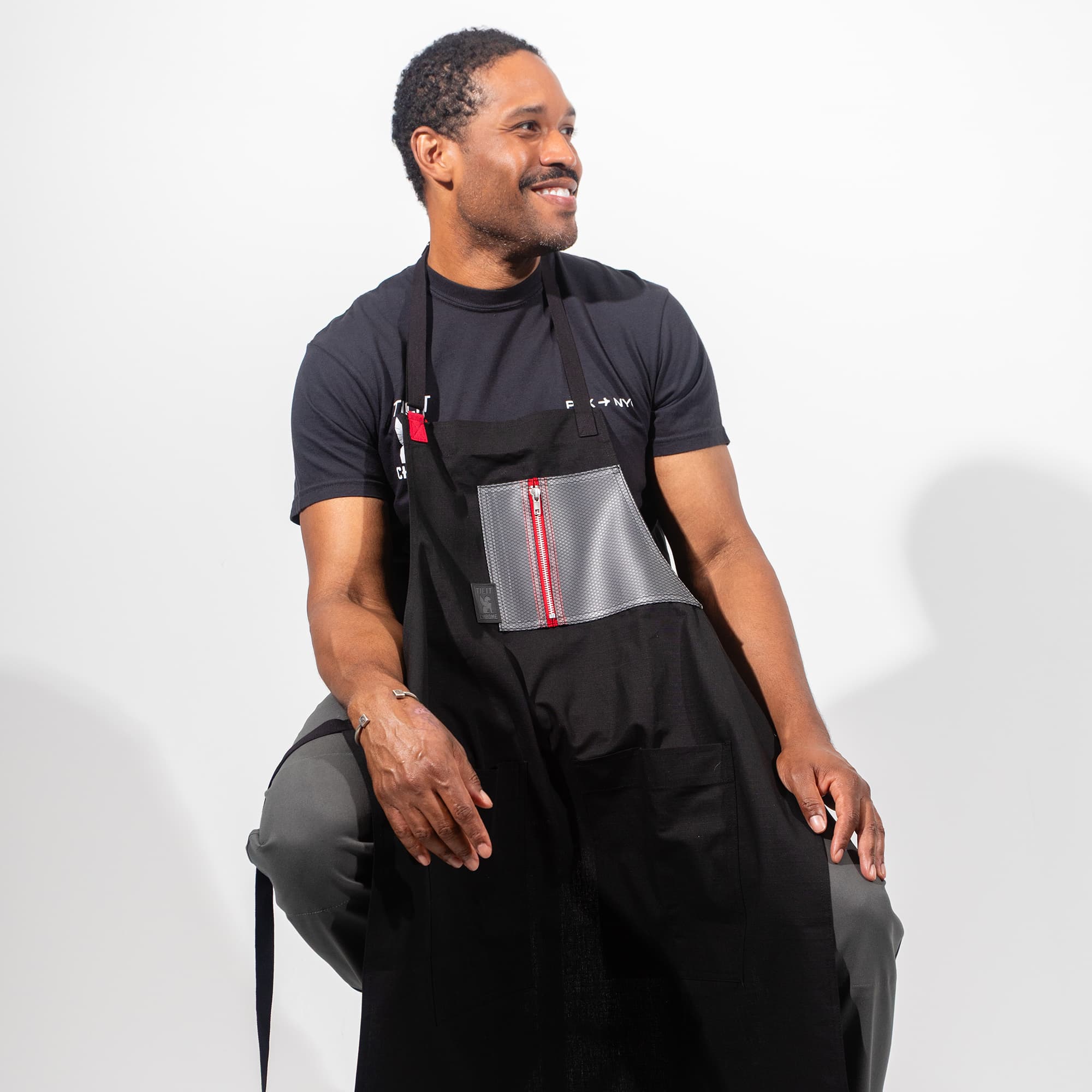Chrome x Tilit Chef Apron on a guy sitting on a stool