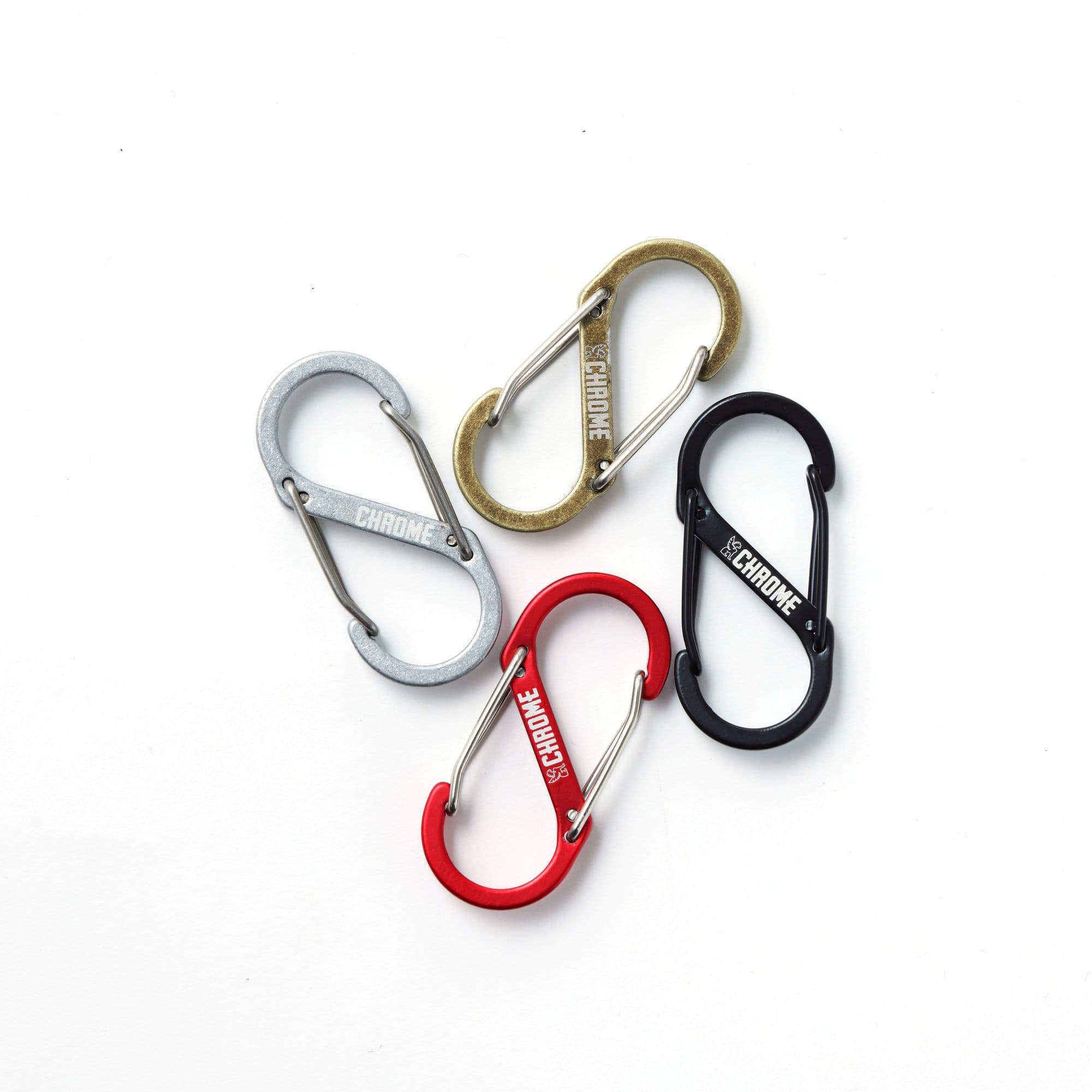 Four small carabiners in different colors (silver, gold, red, black) all with a Chrome logo.