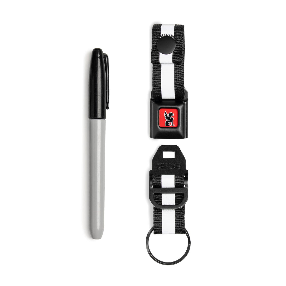 Our updated Mini Buckle Keychain in Black and Red open and next to a sharpie for scale #color_black / red