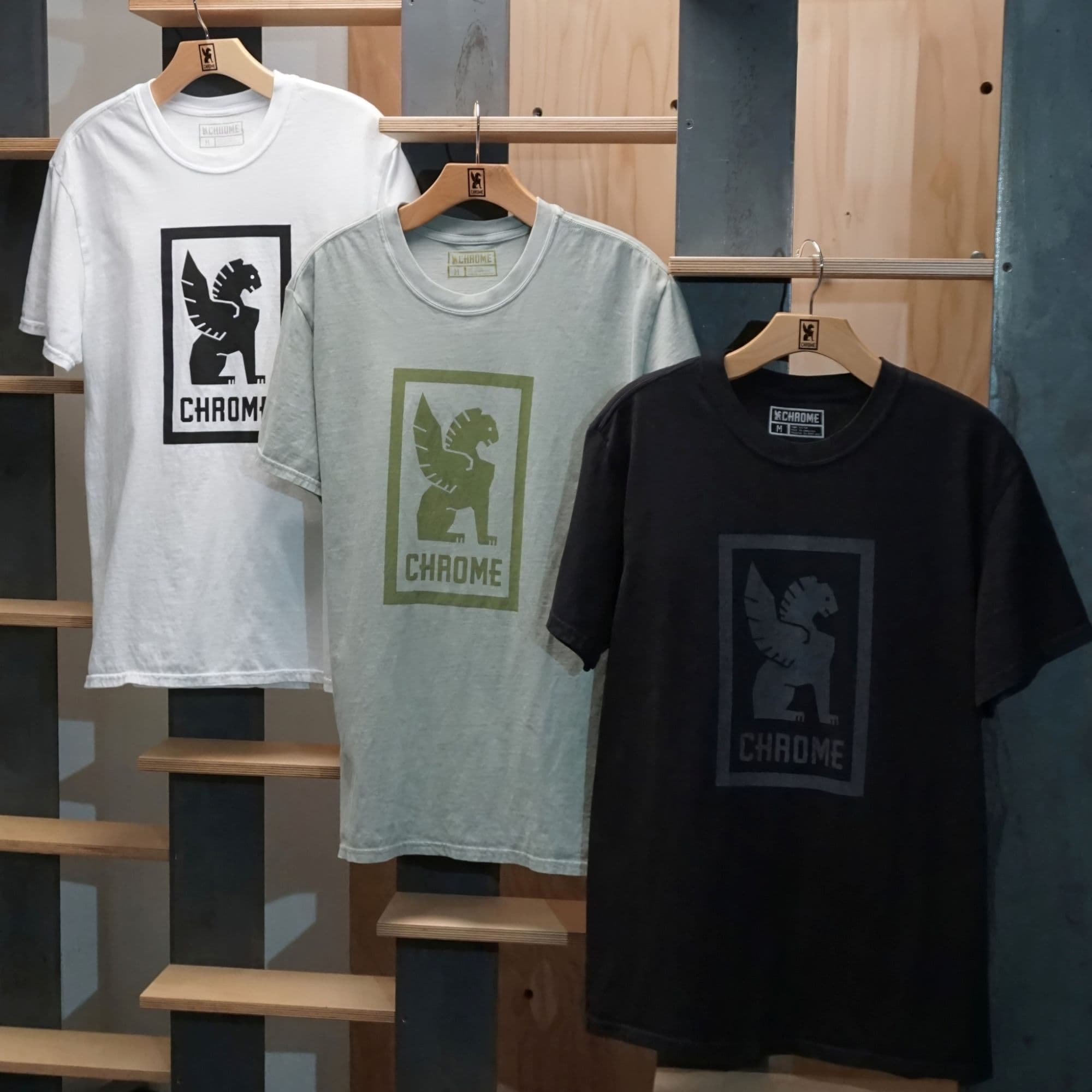 Three t-shirts with Chrome Industries logos on hangers