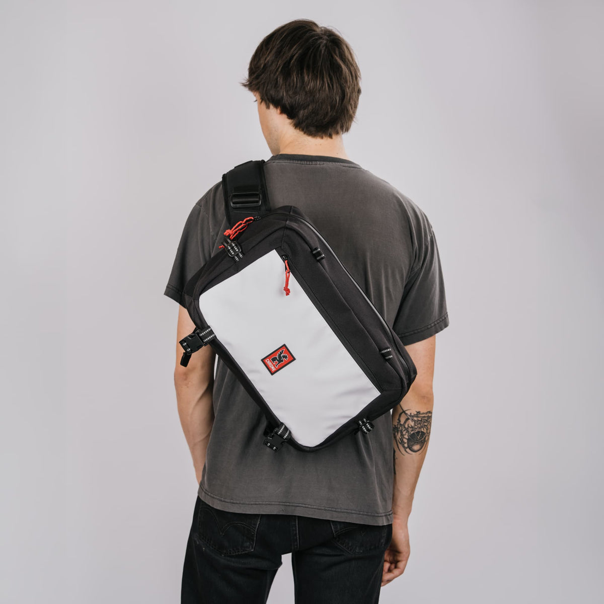 Kadet Max Sling in Classic Black White on the back of a guy #color_classic / black / white