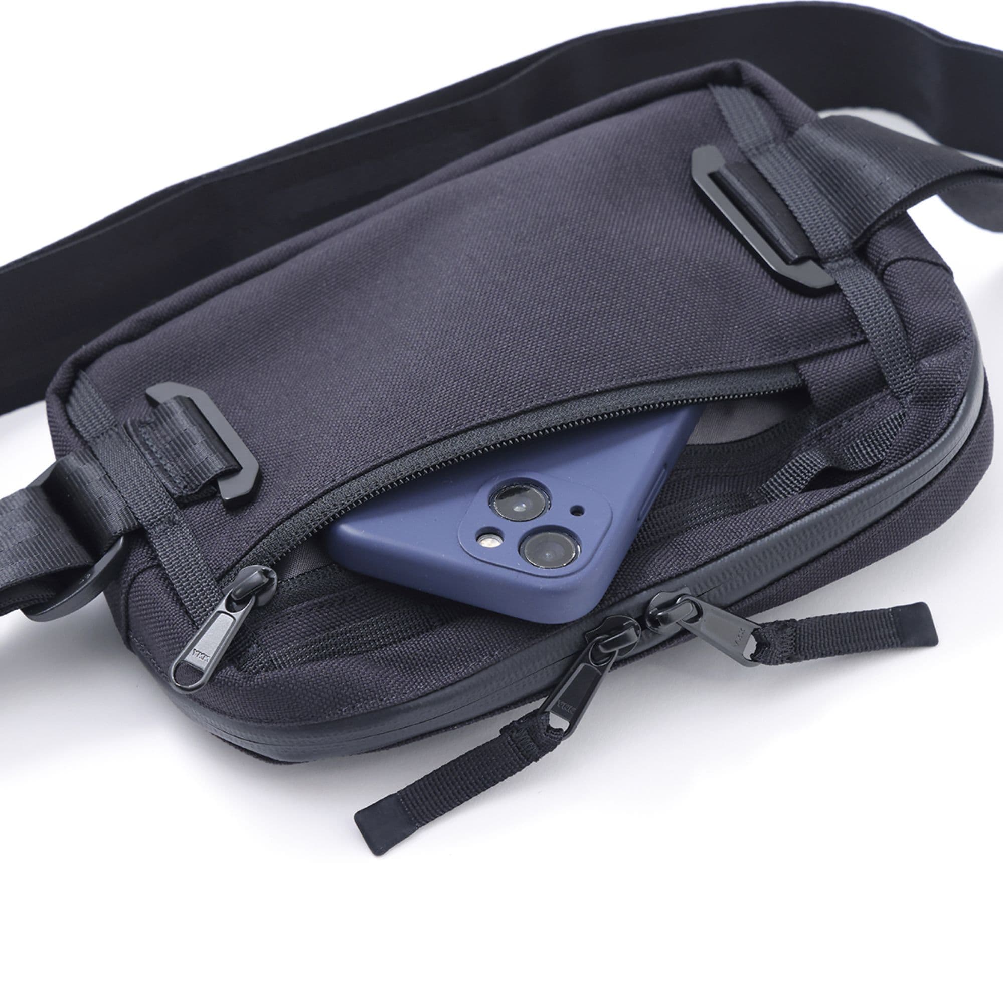 A phone in the back zipper of the Barrage 2L sling