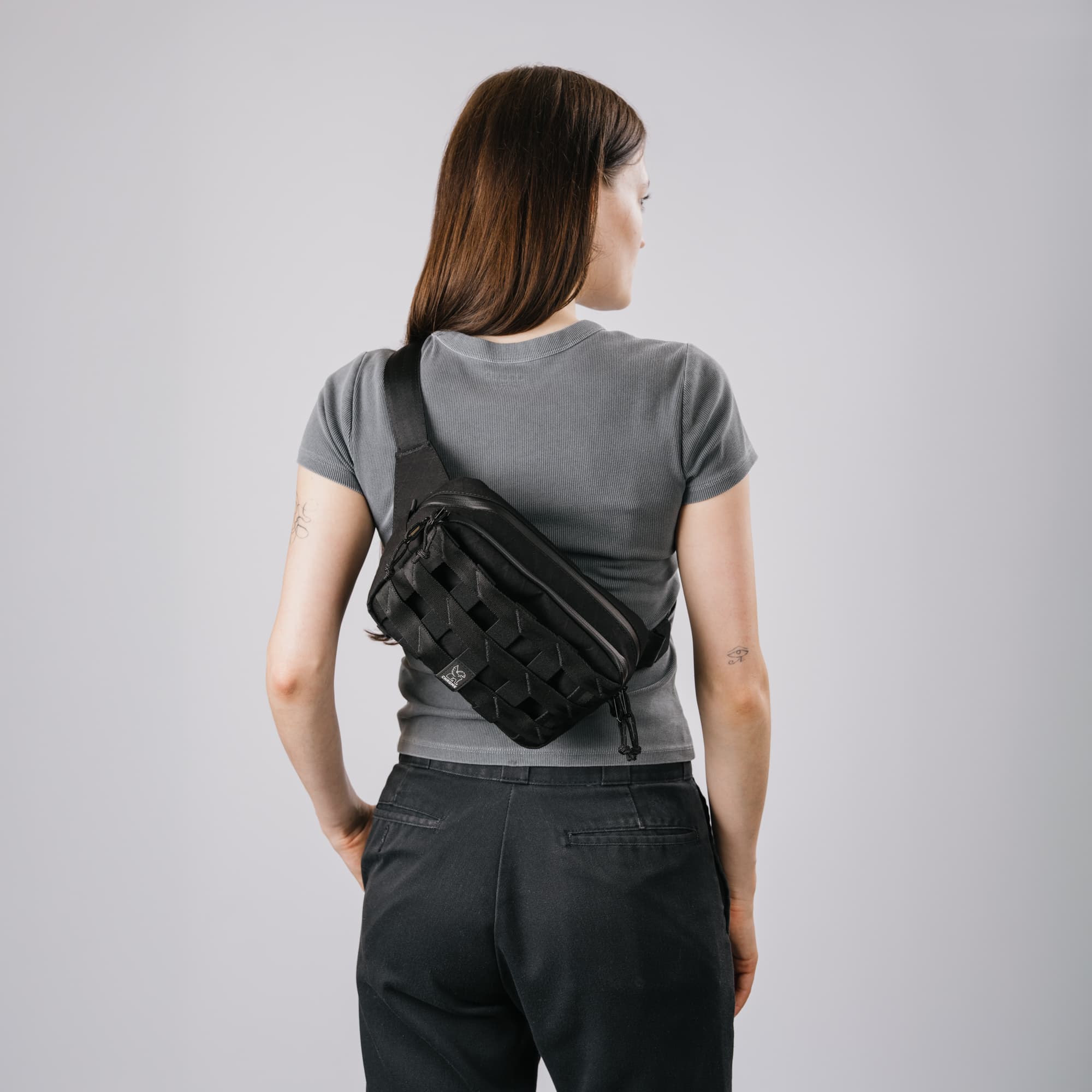 The new Barrage 5L sling on a Woman, back view of the black x2 sling