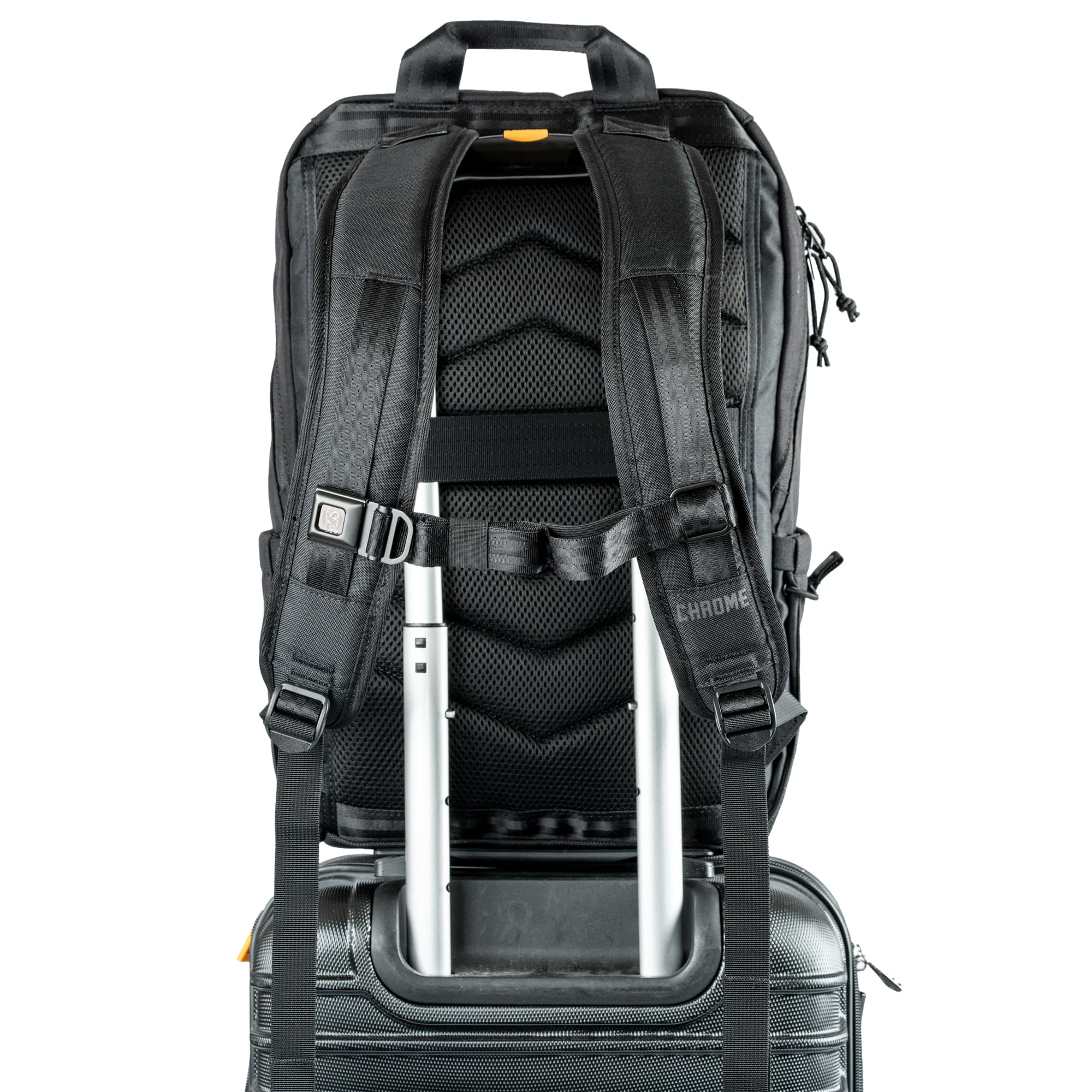 The Recruit 22L Pack is sitting on a piece of luggage with the luggage pass through over the bar.