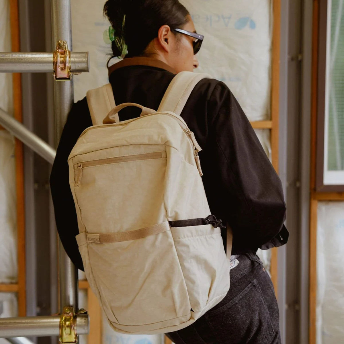 A person in Japan standing by a scaffold with the Grocery 22L Pack in Chalk on #color_chalk