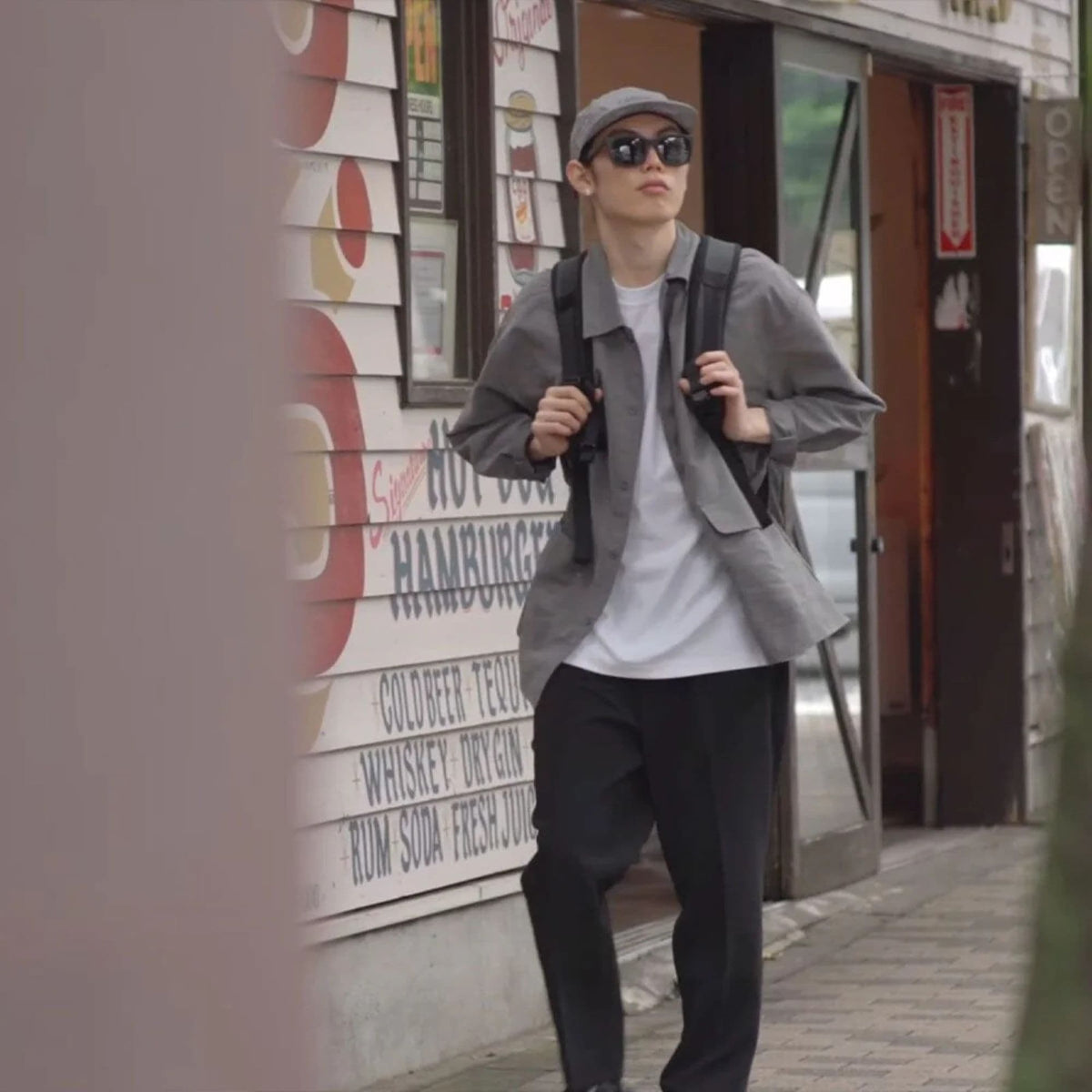 A person wearing the new Grocery 22L Pack in Matte black walking in Japan #color_matte black