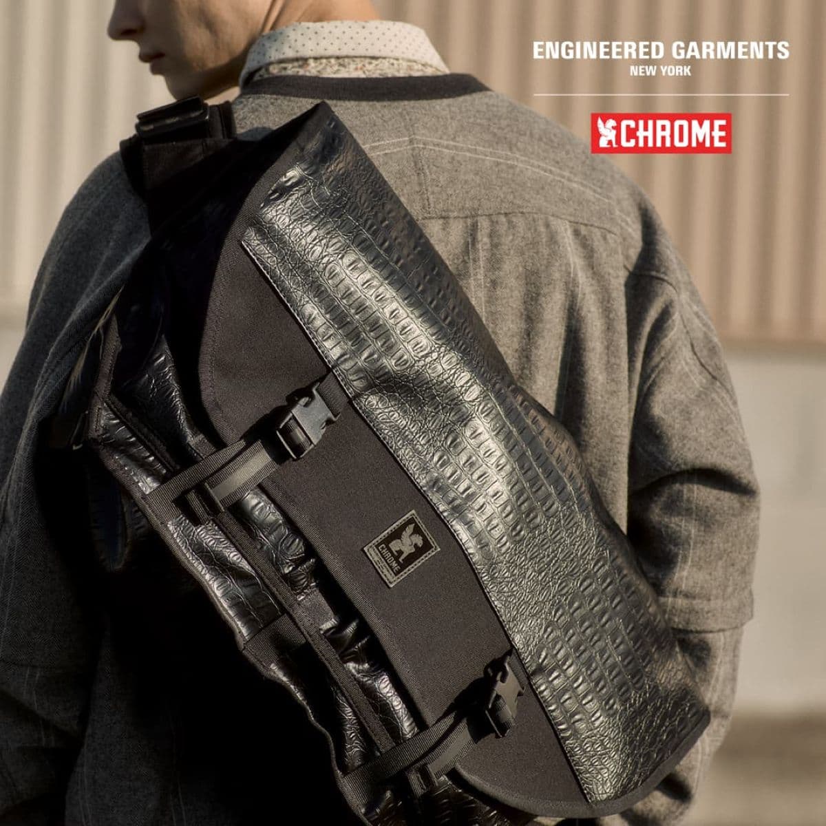 Person wearing a textured black backpack with 'Chrome' branding, on a blurred background.