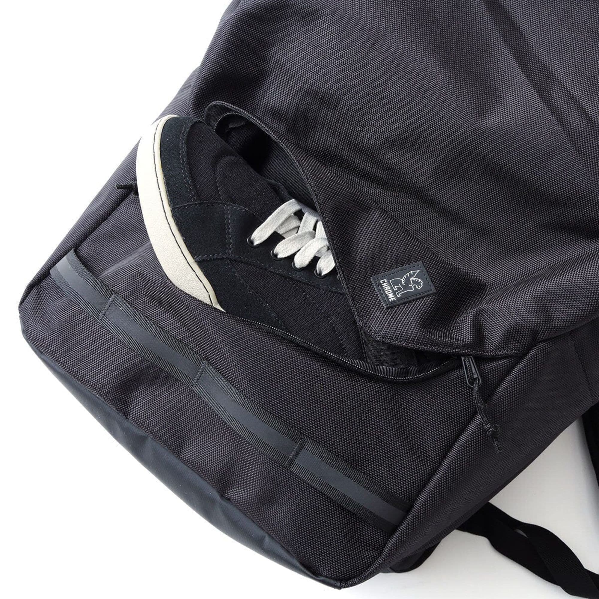 The front pocket holding a shoe of the Extlek 24L Backpack in black