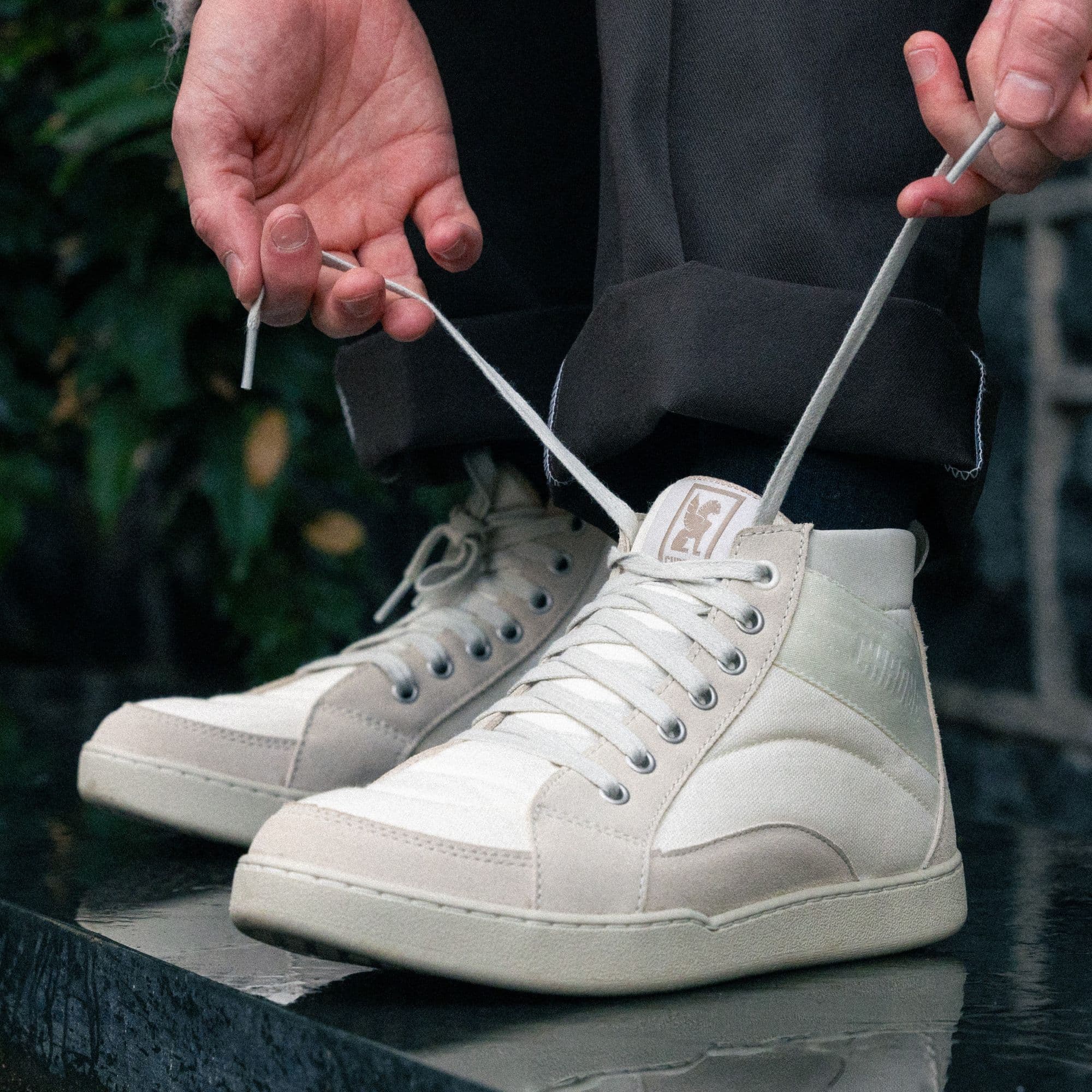 Tying the laces of the Foster High Top in cloud white