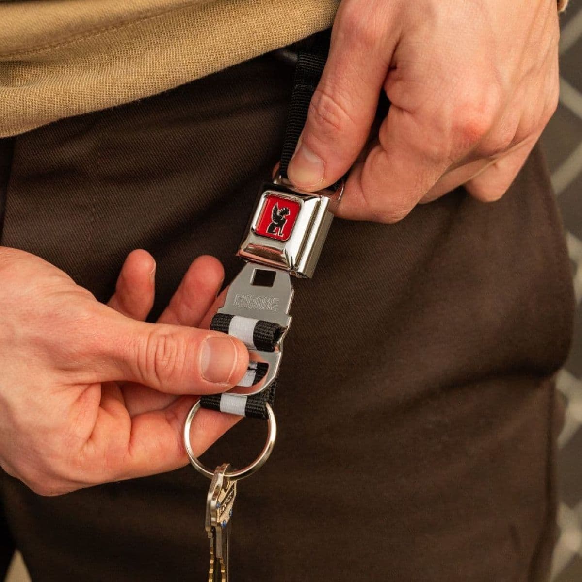 The Mini Buckle Keychain on a persons belt