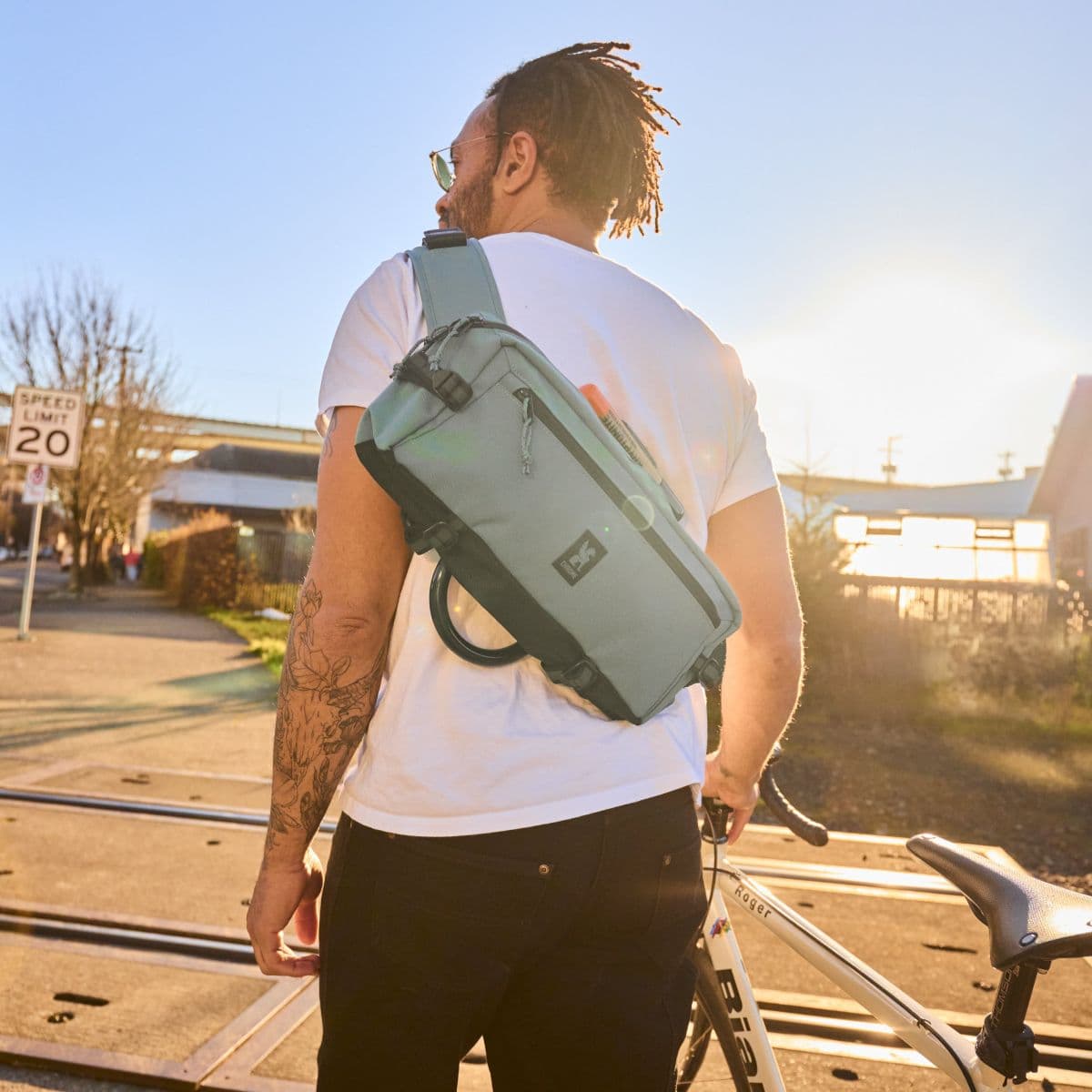A guy wearing the Kadet in Steel Blue holding his bike