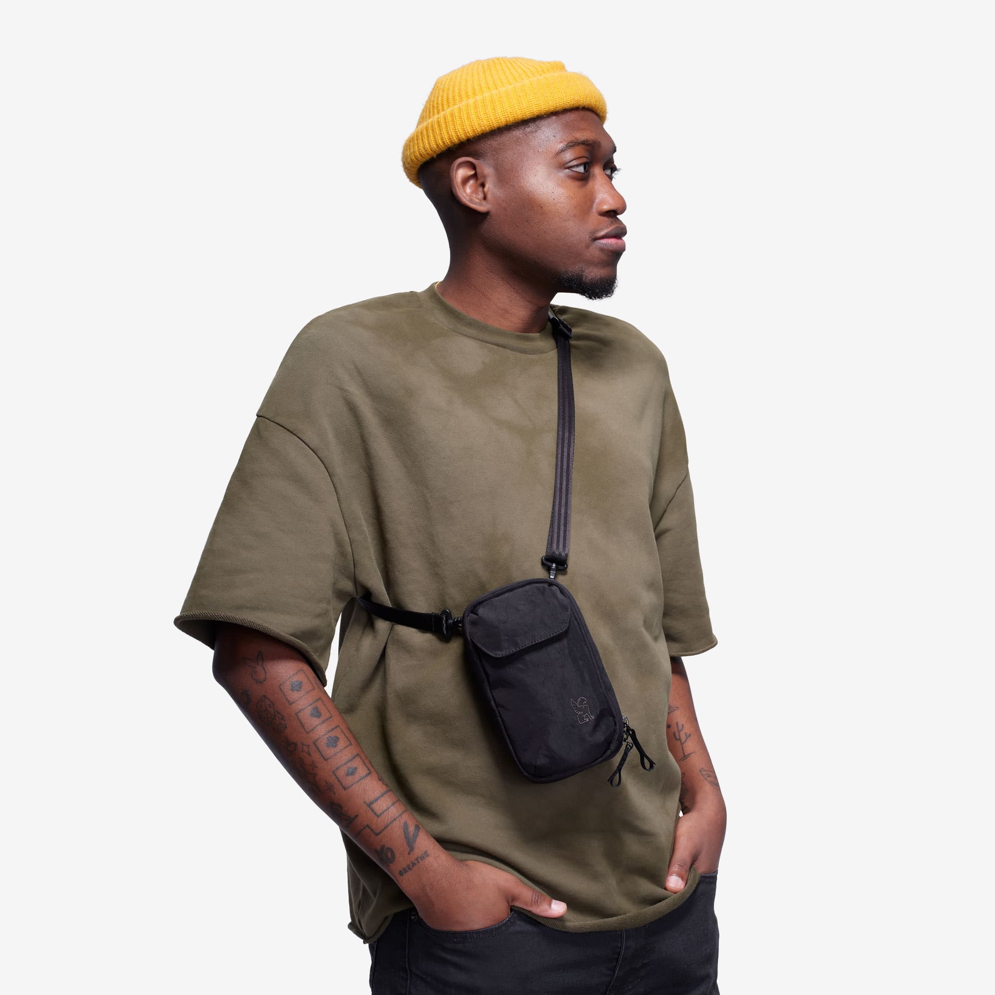 A man with the logan pouch wearing it as a cross body #color_black