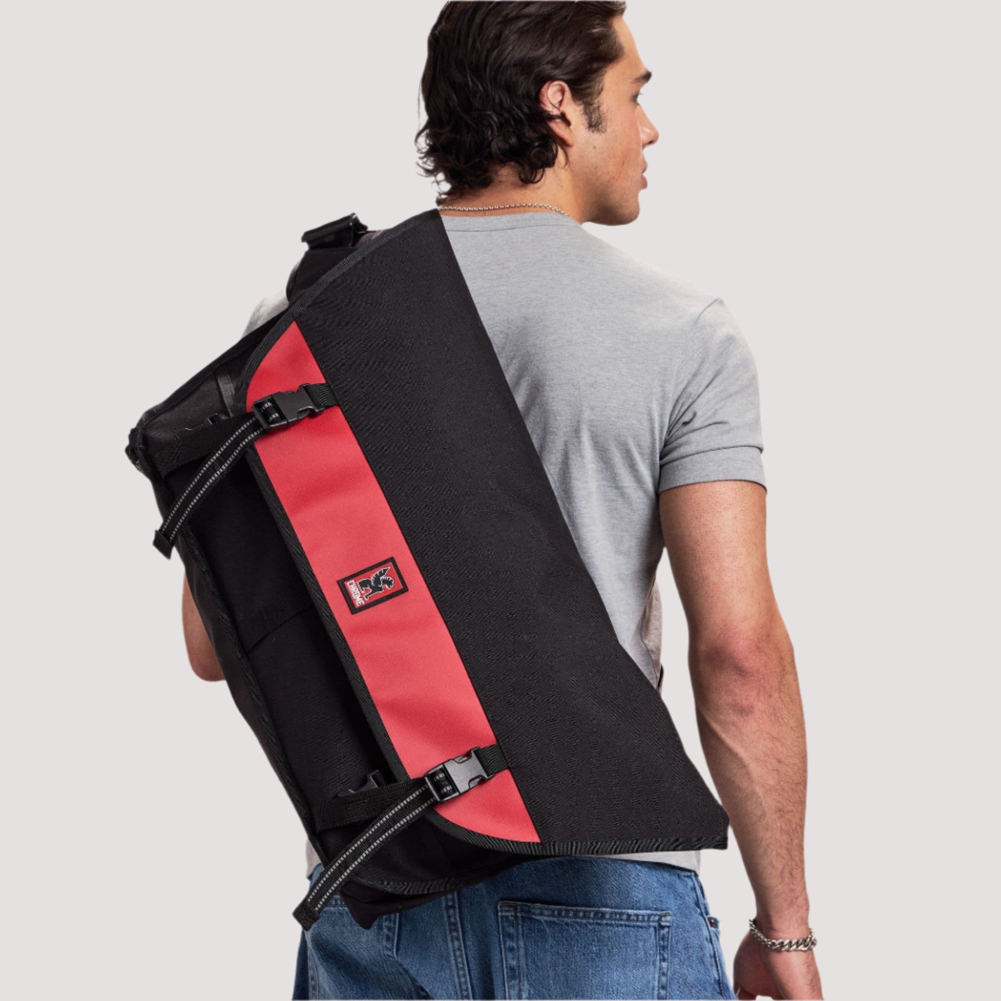 A man looking over his shoulder carrying a 40L Metropolis Messenger