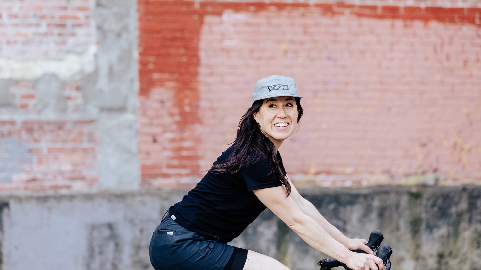 5-panel hat being worn by a woman riding a bike