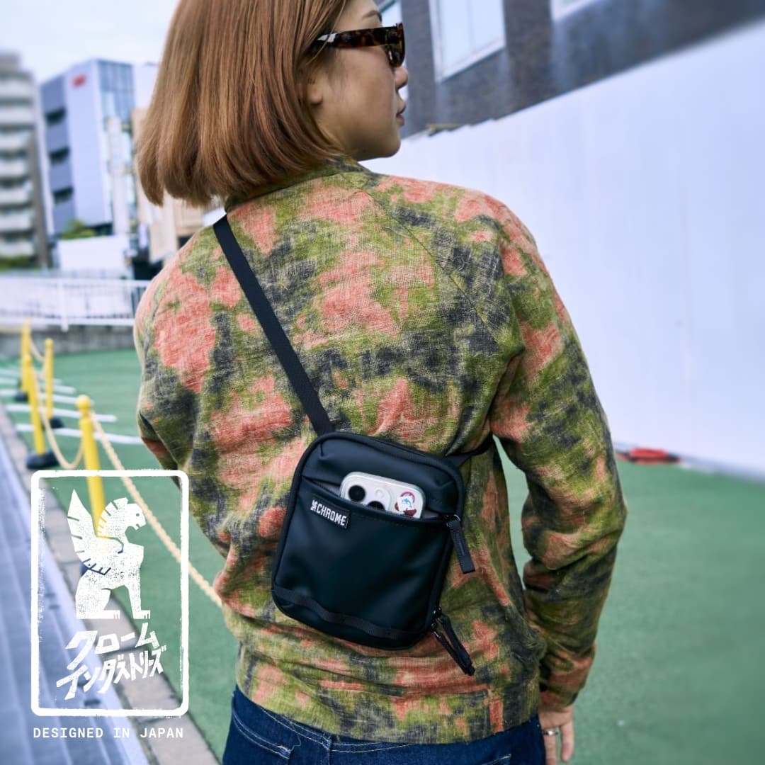 A woman wearing the Pac Pouch 2L in Matte Black around Tokyo