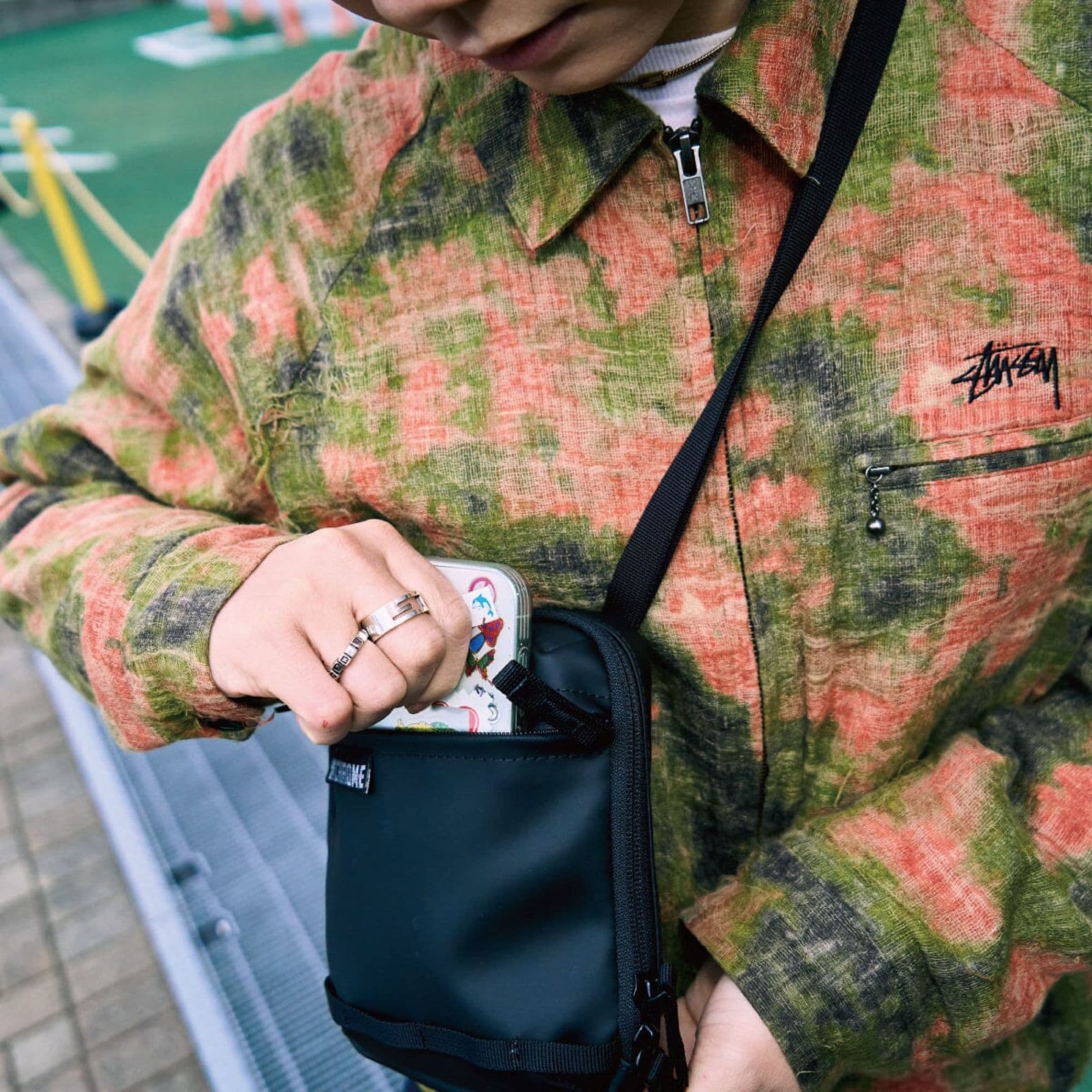 A woman putting her phone in the Pac Pouch 2L