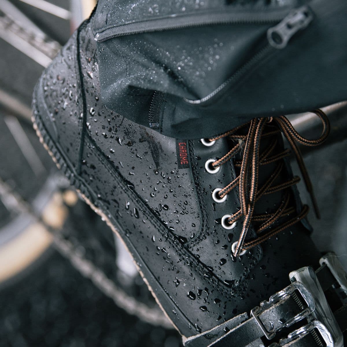 Waterproof Black boot with water droplets on a blurred background