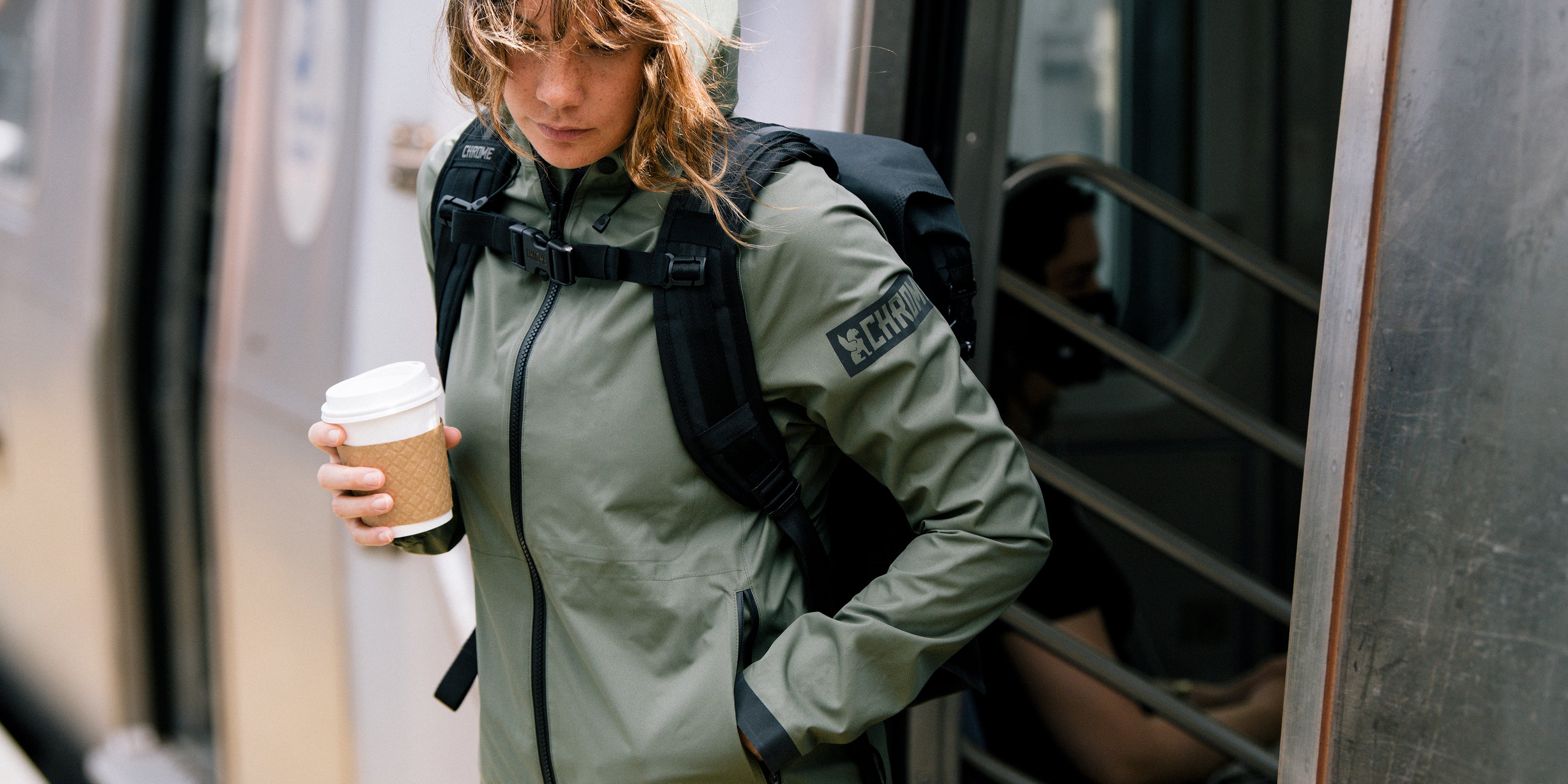 Woman's Storm Salute Commute Jacket in green worn by a woman desktop size 