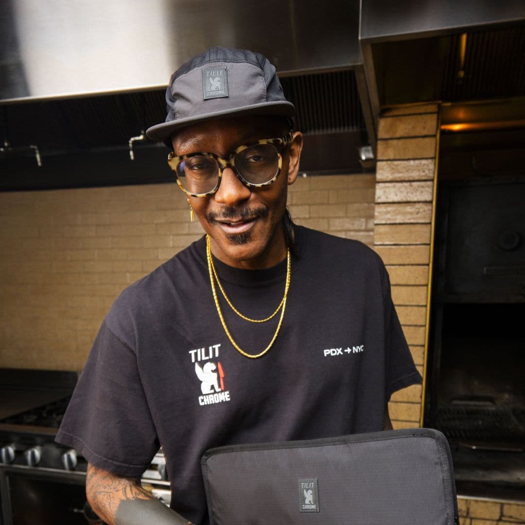 A Portland Chef wearing the Commute Cap and holding the new knife roll