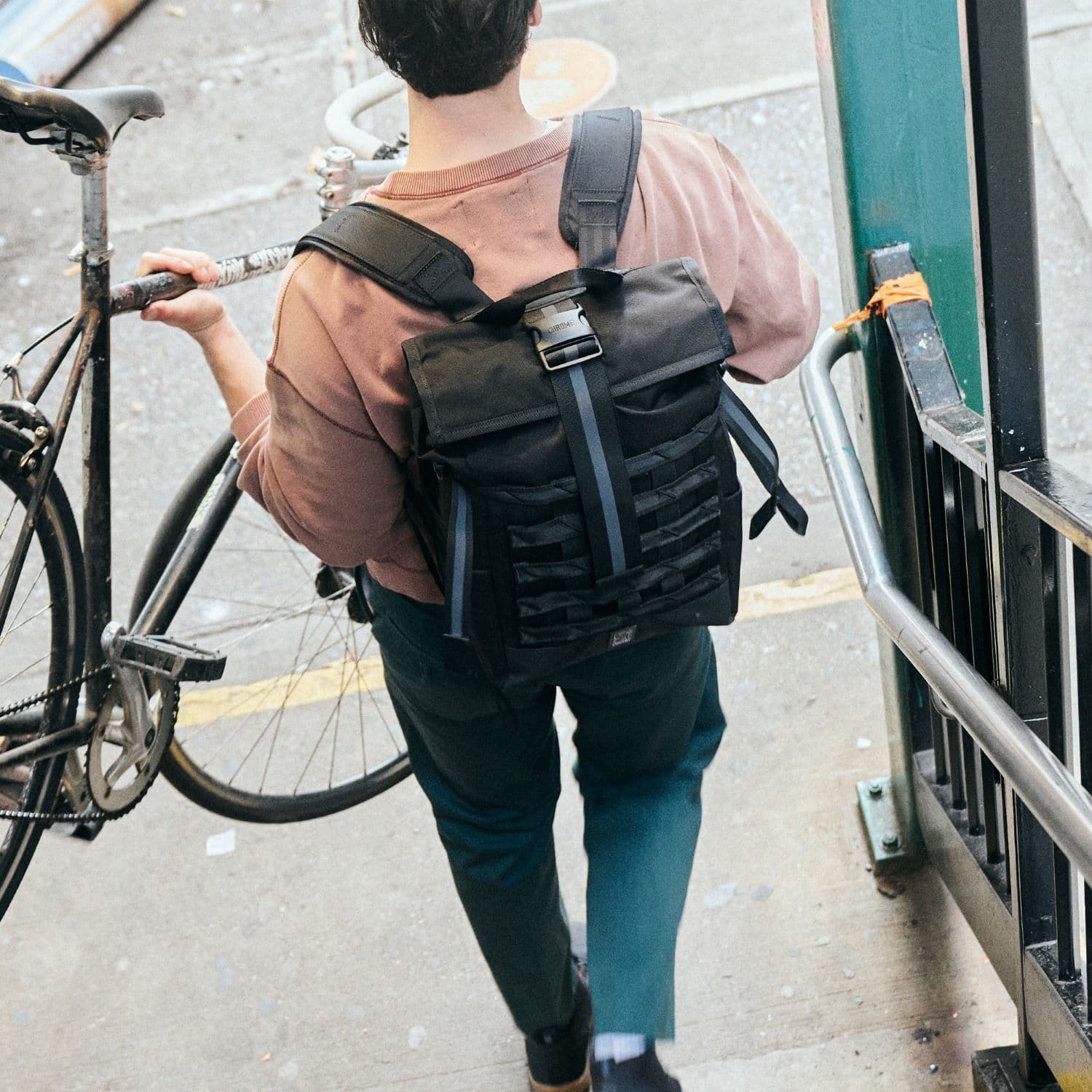 Man wearing the Barrage 22L carrying his bike