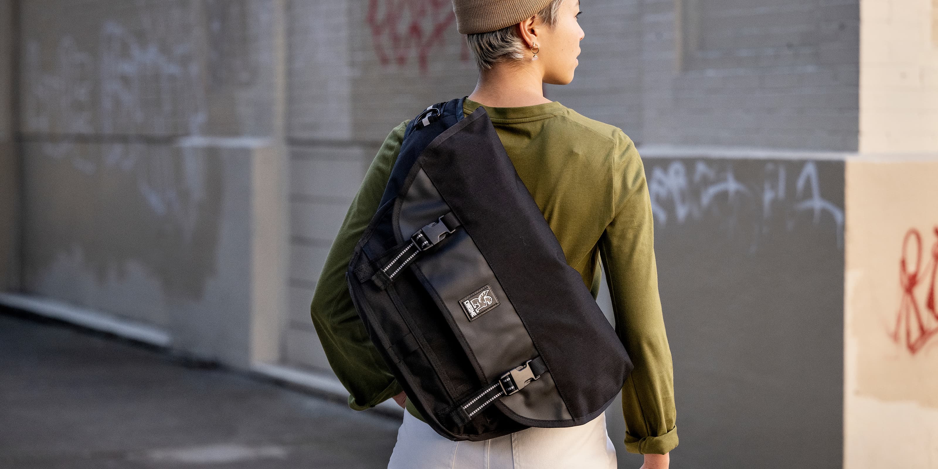 Water-resistant Mini Metro Messenger in black worn by a person