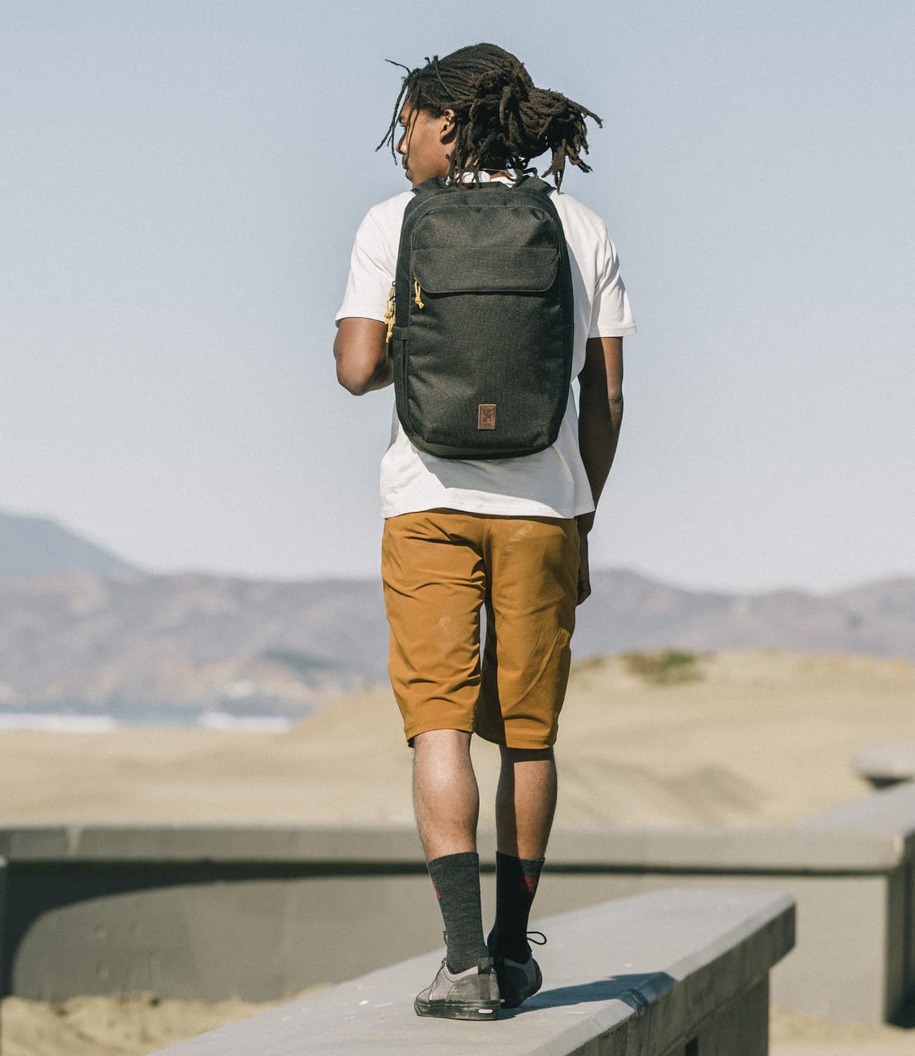 Water-resistant Ruckas 23L Backpack worn by a person on the beach