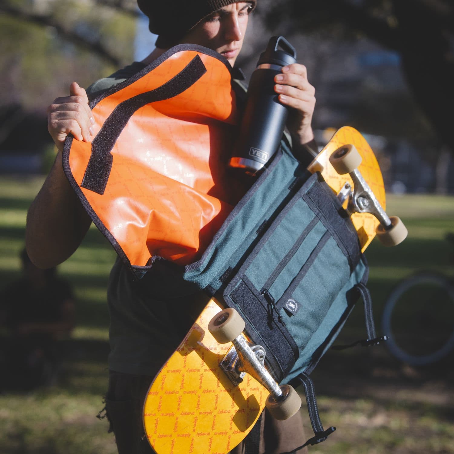 A person loading a water bottle into the Citizen Skate Messenger