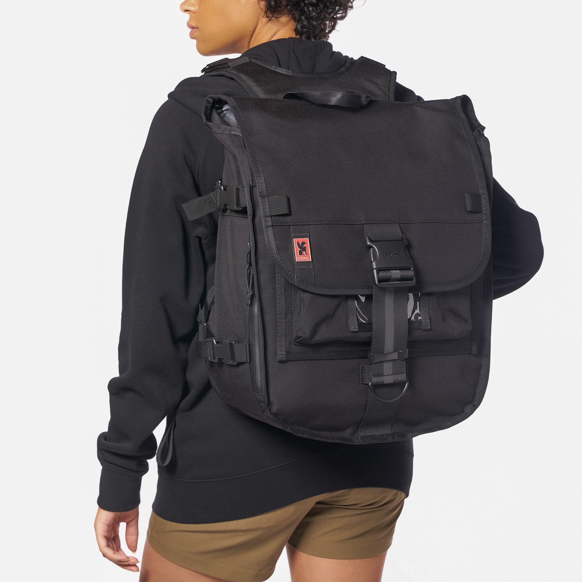 Warsaw medium size flap backpack in black worn by a woman