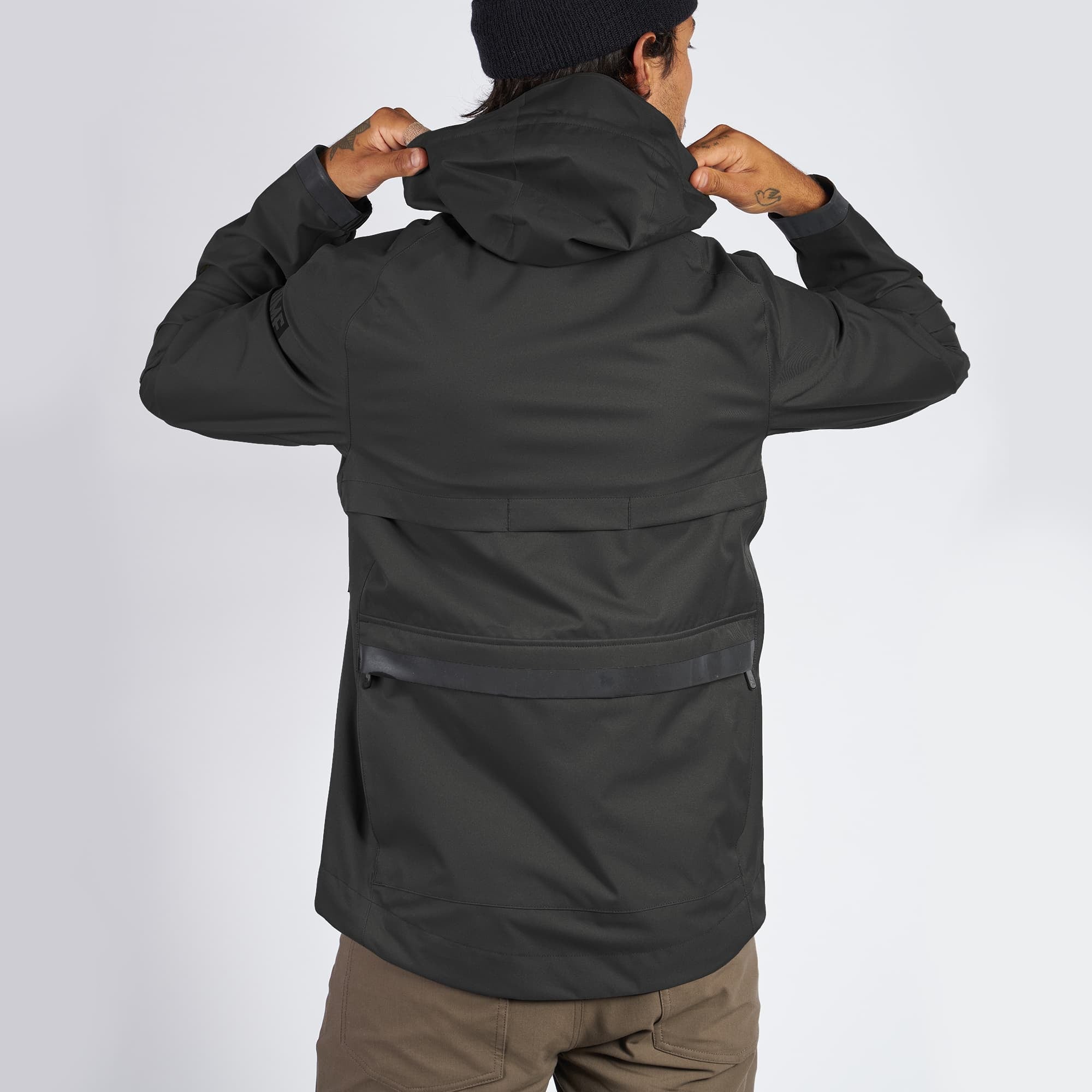 Waterproof rain jacket in black worn by a man back hood detail